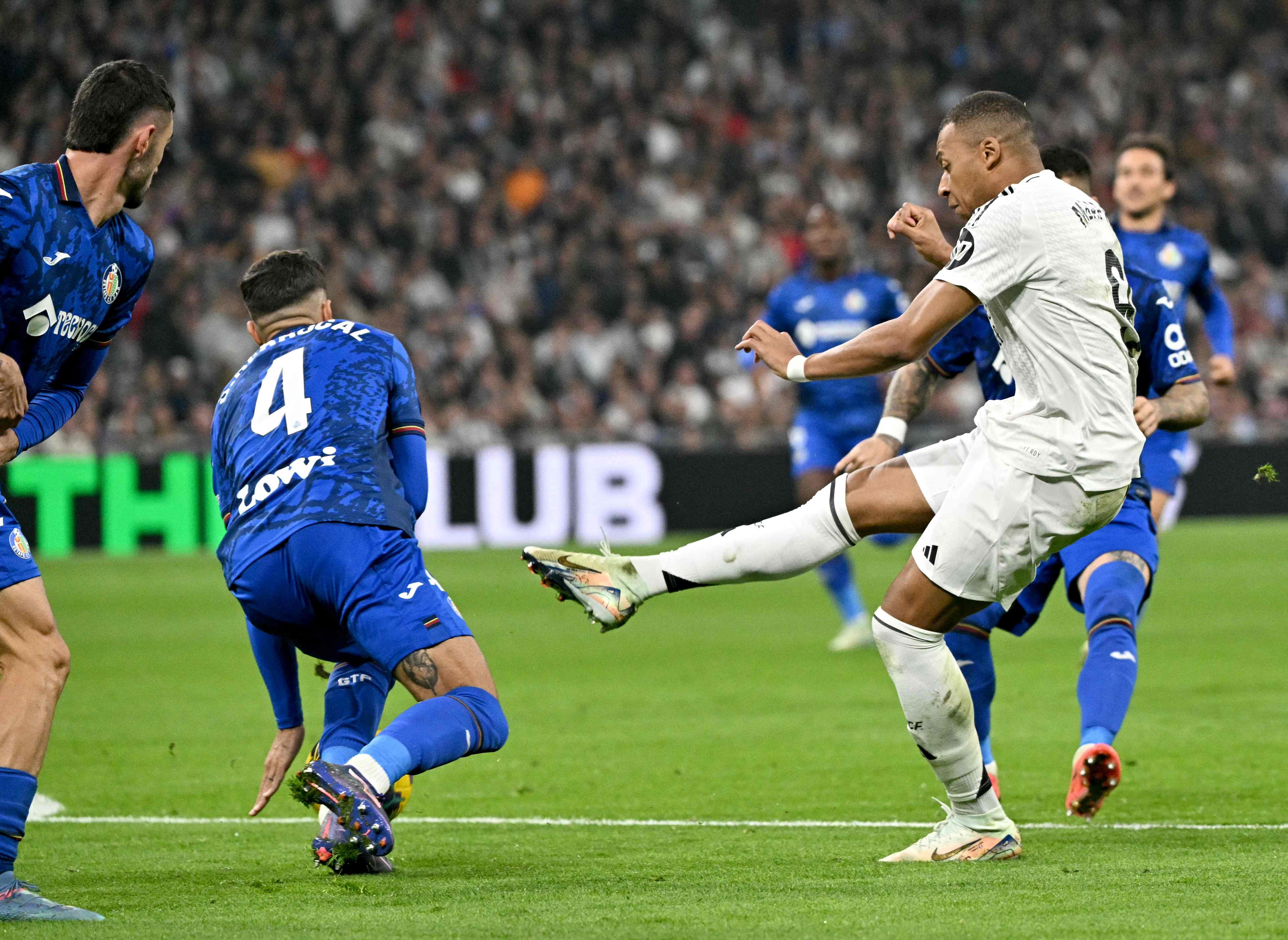 Real Madrid's French forward #09 Kylian Mbappe fights for the ball with Getafe's Spanish defender #04 Juan Berrocal during the Spanish league football match between Real Madrid CF and Getafe CF at the Santiago Bernabeu stadium in Madrid on December 1, 2024. (Photo by JAVIER SORIANO / AFP)