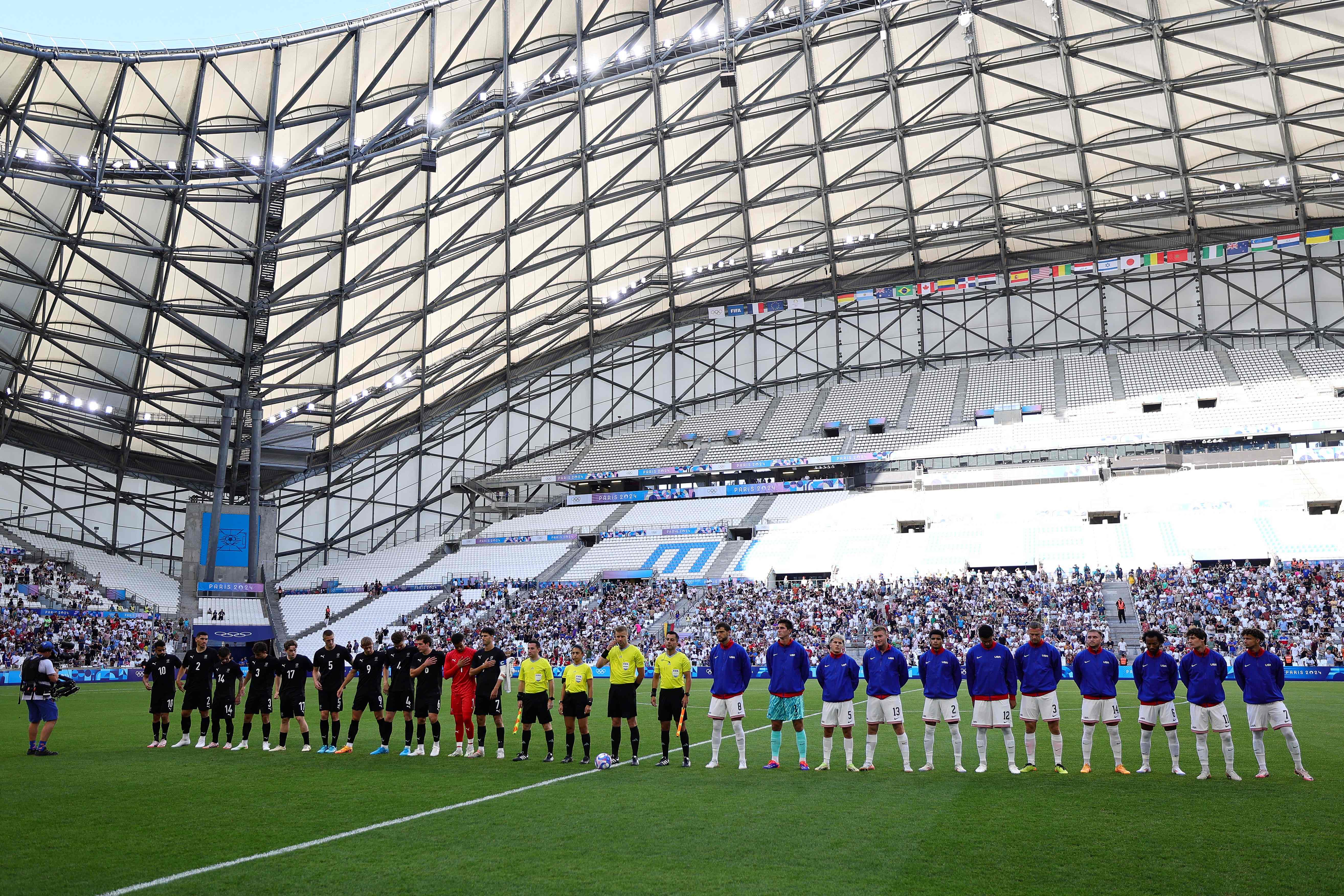 Players line up before the start of the men's group A football match between New Zealand and the USA during the Paris 2024 Olympic Games at the Marseille Stadium in Marseille on July 27, 2024. (Photo by Clement MAHOUDEAU / AFP)