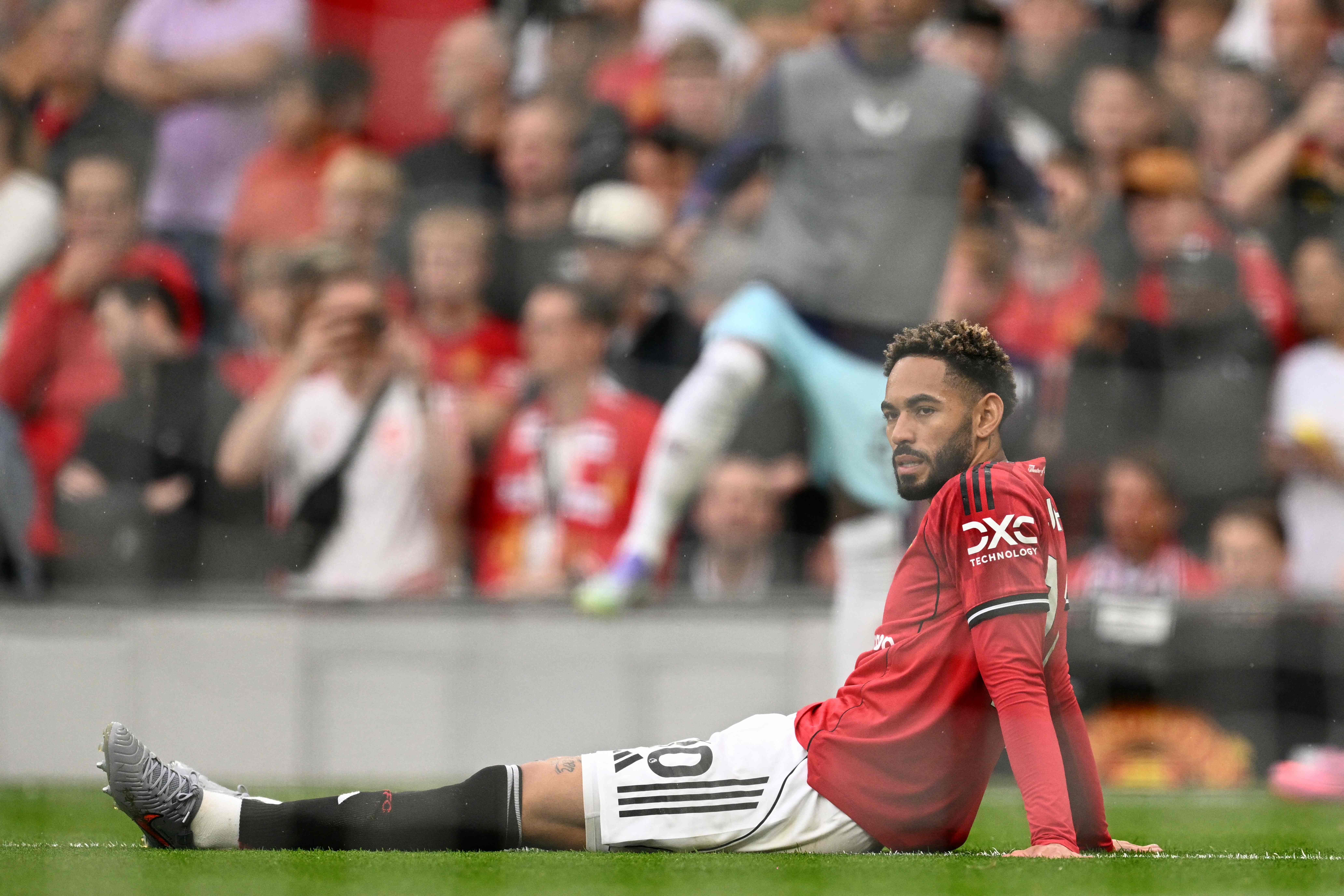 Manchester United's Brazilian striker #10 Matheus Cunha sits on the pitch after pulling up and going down injured during the English Premier League football match between Manchester United and Burnley at Old Trafford in Manchester, north west England, on August 30, 2025. (Photo by Oli SCARFF / AFP) / RESTRICTED TO EDITORIAL USE. No use with unauthorized audio, video, data, fixture lists, club/league logos or 'live' services. Online in-match use limited to 120 images. An additional 40 images may be used in extra time. No video emulation. Social media in-match use limited to 120 images. An additional 40 images may be used in extra time. No use in betting publications, games or single club/league/player publications. / 
