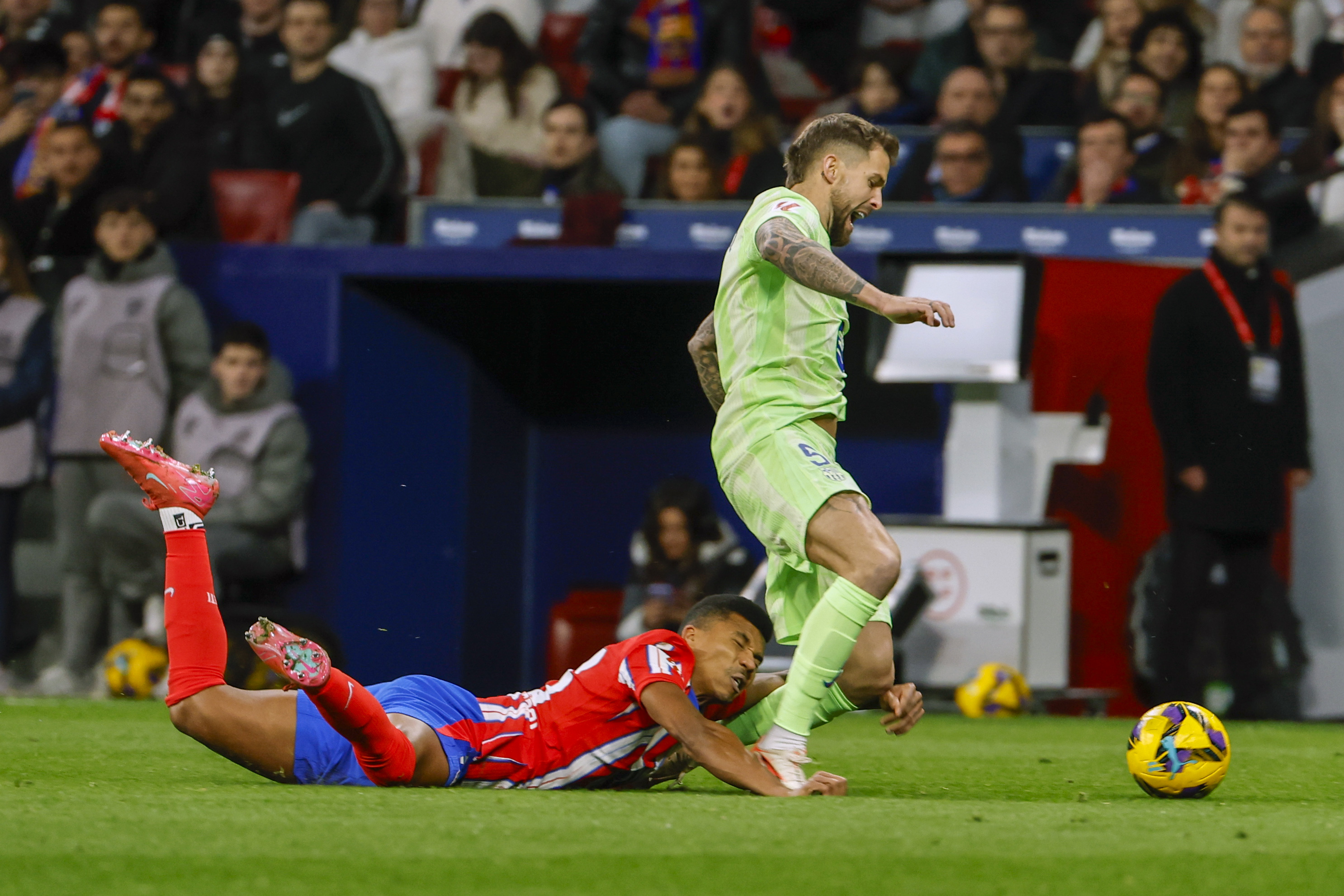 MADRID, 16/03/2025.- El centrocampista mozambique?o del Atltico de Madrid, Reinildo Mandava (i), cae ante el defensa del FC Barcelona, I?igo Martnez, durante el encuentro correspondiente a la jornada 28 de Laliga EA Sports que disputan hoy domingo Atltico de Madrid y FC Barcelona en el estadio Metropolitano, en Madrid. EFE / J.J.Guillen.
