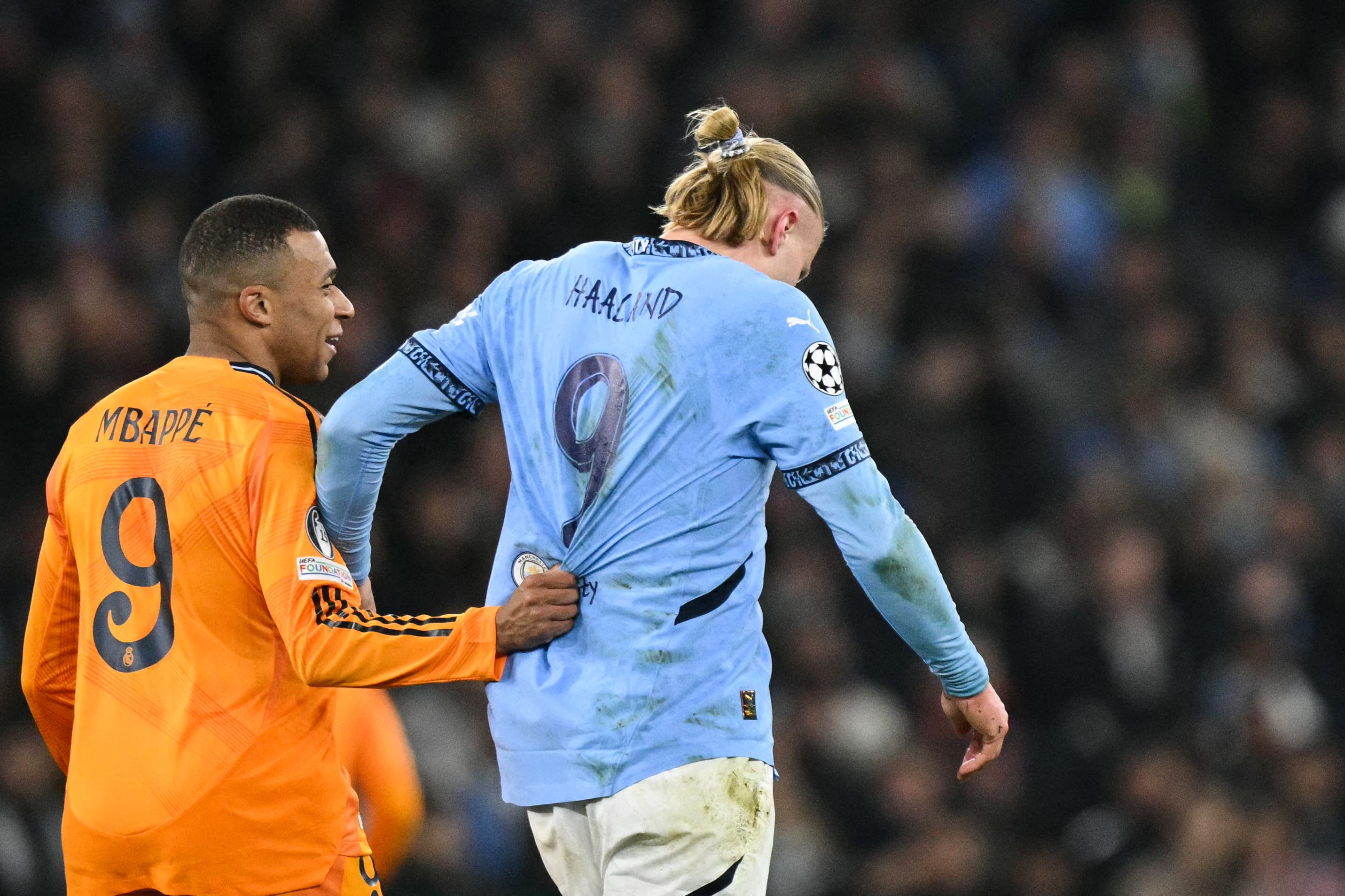 Real Madrid's French forward #09 Kylian Mbappe (L) pull sthe jersey of Manchester City's Norwegian striker #09 Erling Haaland during the UEFA Champions League football match between Manchester City and Real Madrid at the Etihad Stadium in Manchester, north west England, on February 11, 2025. (Photo by Oli SCARFF / AFP)