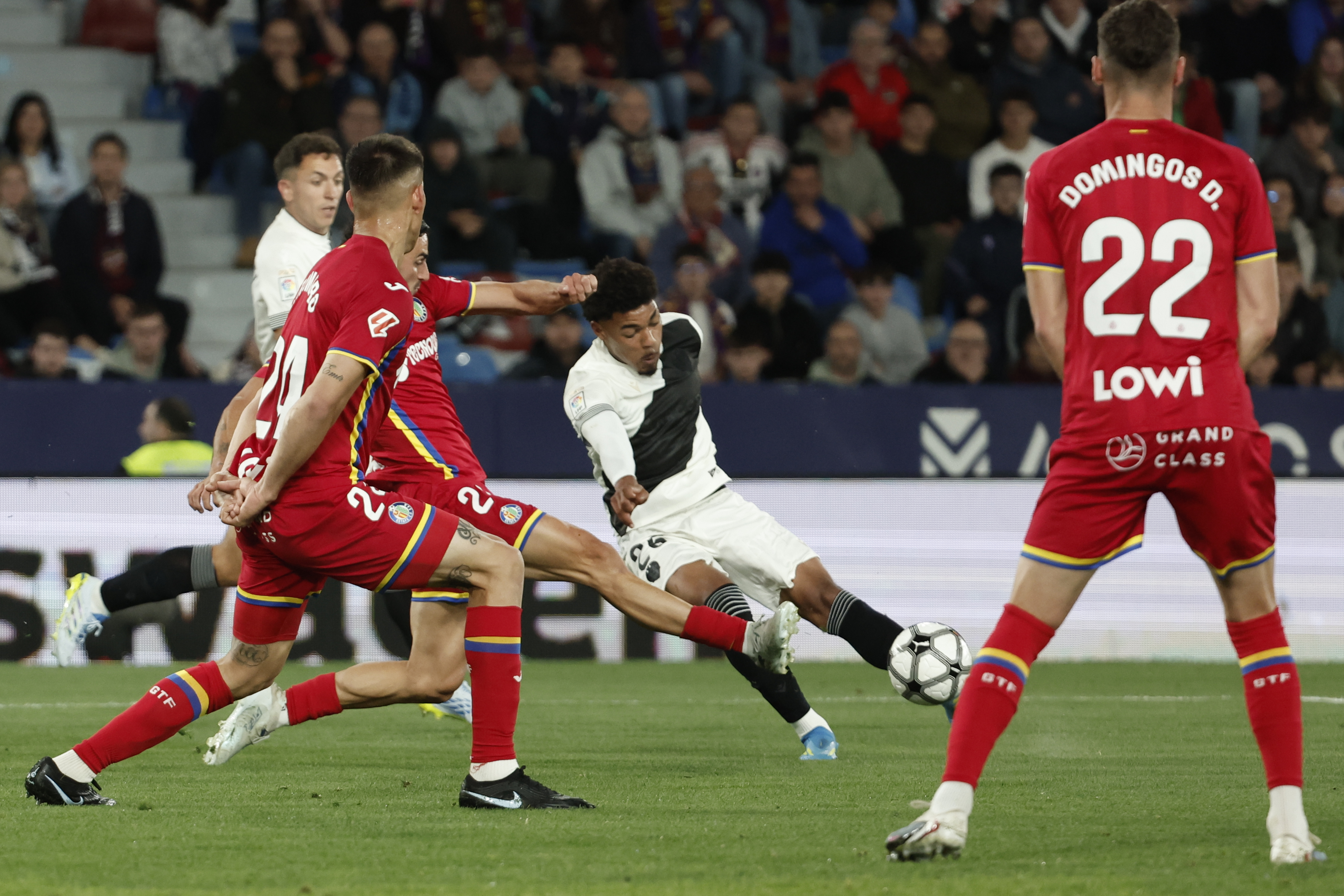 VALENCIA, 13/04/2026.- El defensa del Levante, Manu Sánchez (c), remata ante los defensores del Getafe durante el encuentro correspondiente a la jornada 31 de Laliga EA Sports que disputan este lunes Levante y Getafe en el estadio Ciutat de Valencia. EFE / Manuel Bruque.
