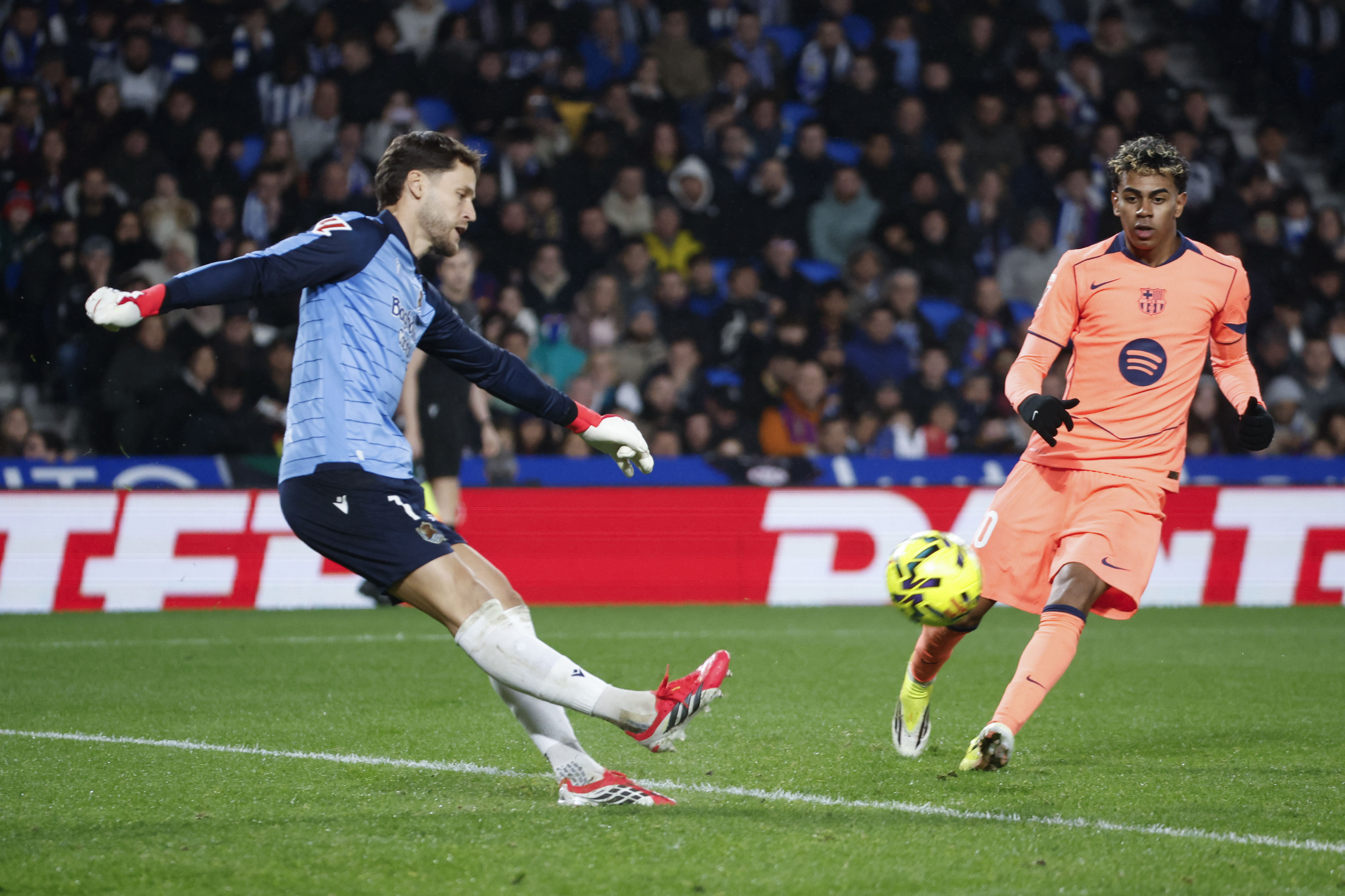 SAN SEBASTIÁN, 18/01/2026.- El portero de la Real, Álex Remiro (i), despeja un balón ante Lamine Yamal, del Barcelona, durante el partido de LaLiga EA Sports que Real Sociedad y FC Barcelona disputan este domingo en el estadio de Anoeta, en San Sebastián. EFE/Javier Etxezarreta
