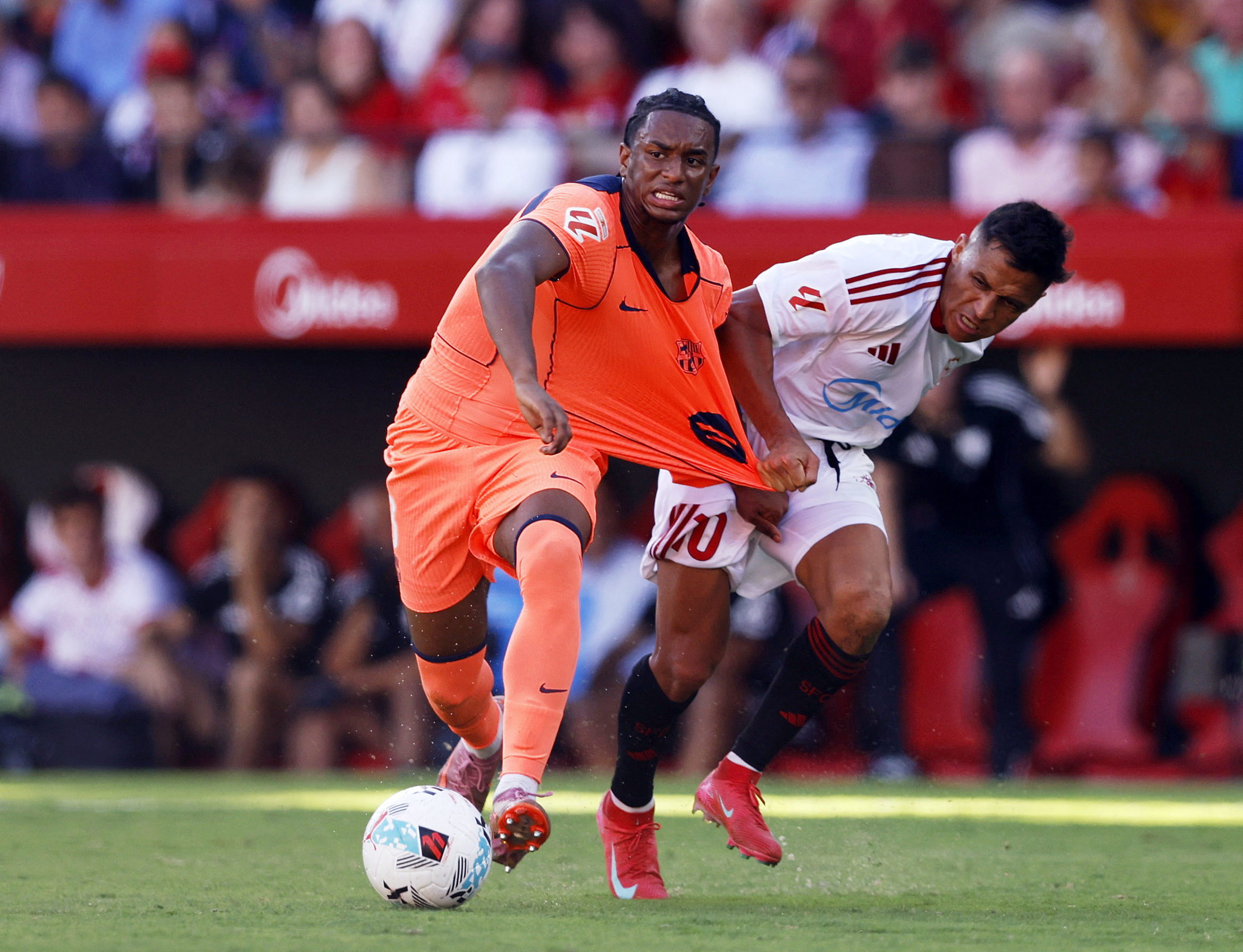 Soccer Football - LaLiga - Sevilla v FC Barcelona - Ramon Sanchez Pizjuan, Seville, Spain - October 5, 2025 FC Barcelona's Alejandro Balde in action with Sevilla's Alexis Sanchez REUTERS/Marcelo Del Pozo