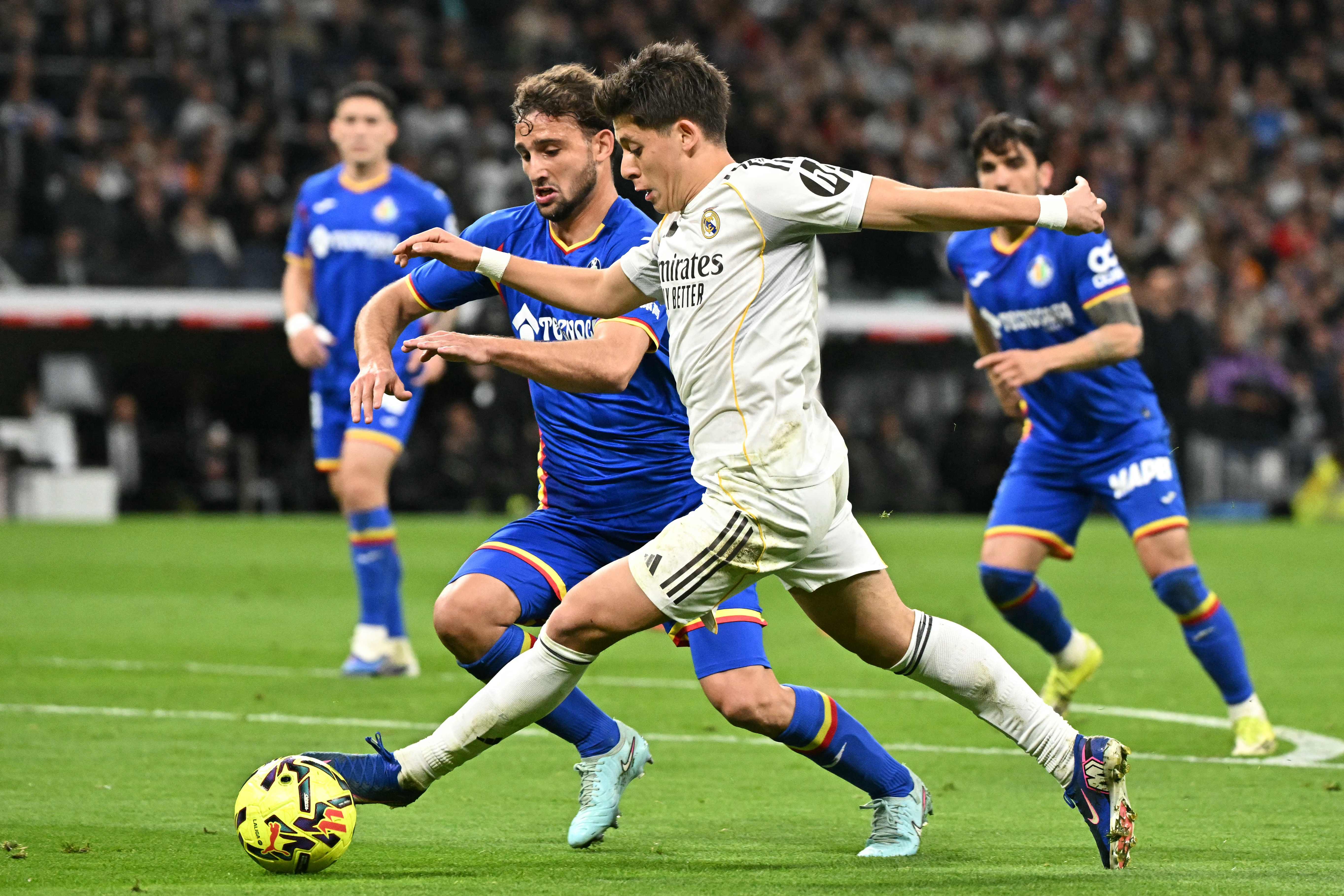 Getafe's Uruguayan defender #15 Sebastian Boselli (L) and Real Madrid's Turkish midfielder #15 Arda Guler fight for the ball during the Spanish league football match between Real Madrid CF and Getafe CF at Santiago Bernabeu Stadium in Madrid on March 2, 2026. (Photo by Javier SORIANO / AFP)
