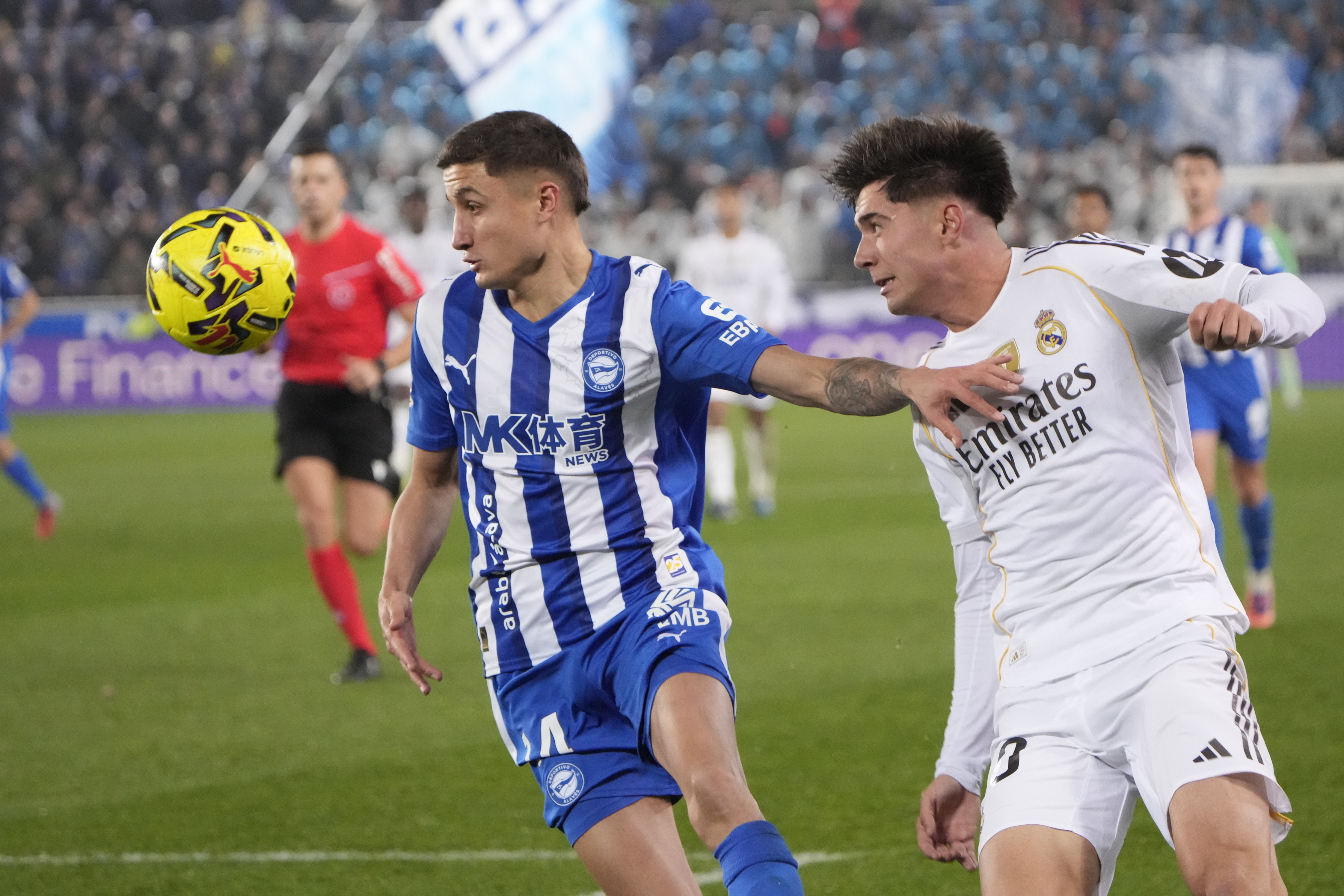 VITORIA (ÁLAVA), 14/12/2025.- El defensa del Real Madrid Víctor Valdepeñas (d) lucha con Nahuel Tenaglia, del Alavés, durante el partido de la jornada 16 de LaLiga que Deportivo Alavés y Real Madrid disputan este domingo en el estadio de Mendizorrotza. EFE/Adrián Ruiz de Hierro
