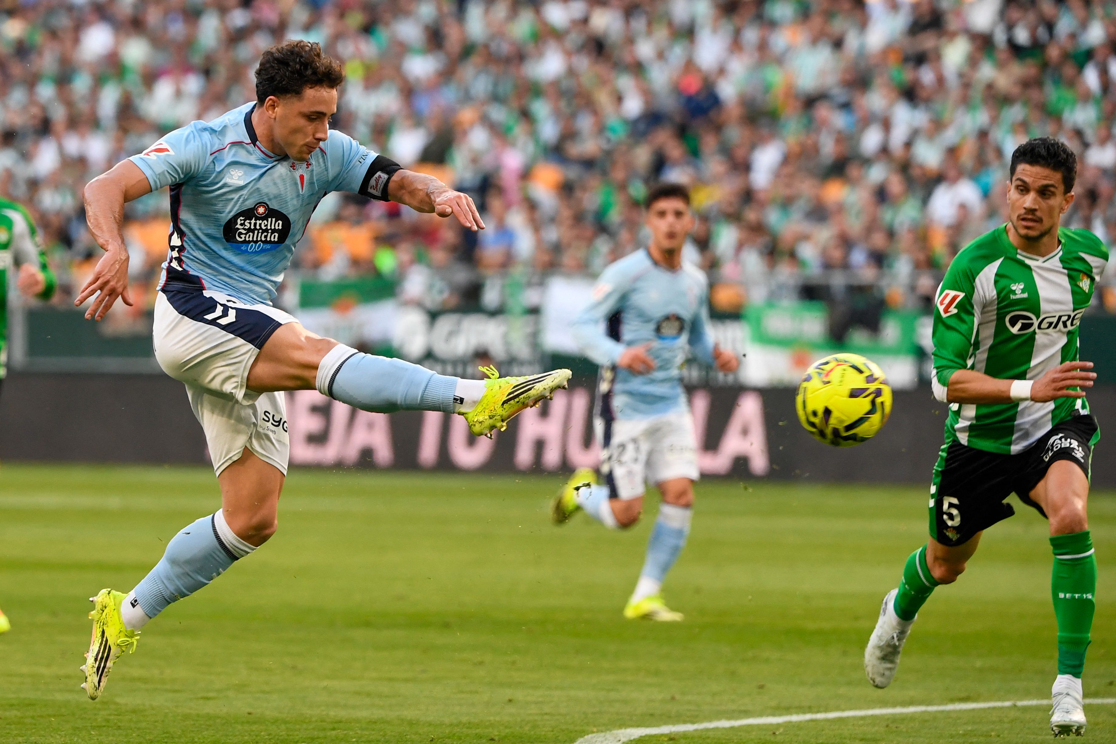 Celta Vigo's Spanish forward #18 Pablo Duran (L) shoots past Real Betis' Spanish defender #05 Marc Bartra during the Spanish league football match between Real Betis and RC Celta de Vigo at Benito Villamarin Stadium in Seville on March 15, 2026. (Photo by CRISTINA QUICLER / AFP)