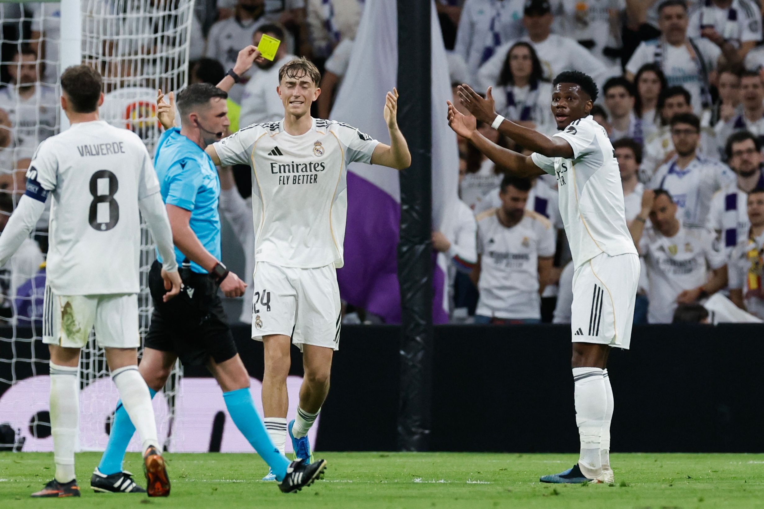 Real Madrid's French midfielder #14 Aurelien Tchouameni (R) reacts as he receives a yellow card from referee Michael Oliver during the UEFA Champions League quarter final first leg football match between Real Madrid CF and FC Bayern Munich at Santiago Bernabeu Stadium in Madrid on April 7, 2026. (Photo by Oscar DEL POZO / AFP)