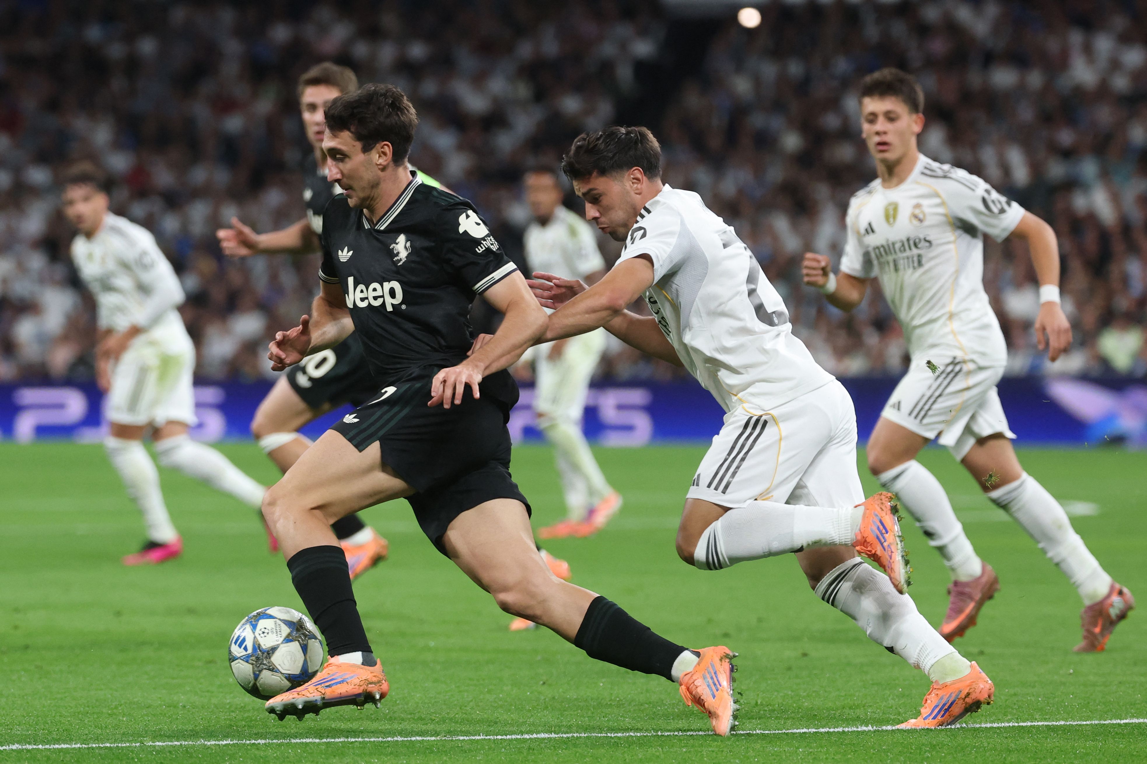 Juventus' Italian defender #27 Andrea Cambiaso (L) is challenged by Real Madrid's Moroccan forward #21 Brahim Diaz during the UEFA Champions League league phase day 3 football match between Real Madrid CF and Juventus at Santiago Bernabeu Stadium in Madrid on October 22, 2025. (Photo by Pierre-Philippe MARCOU / AFP)