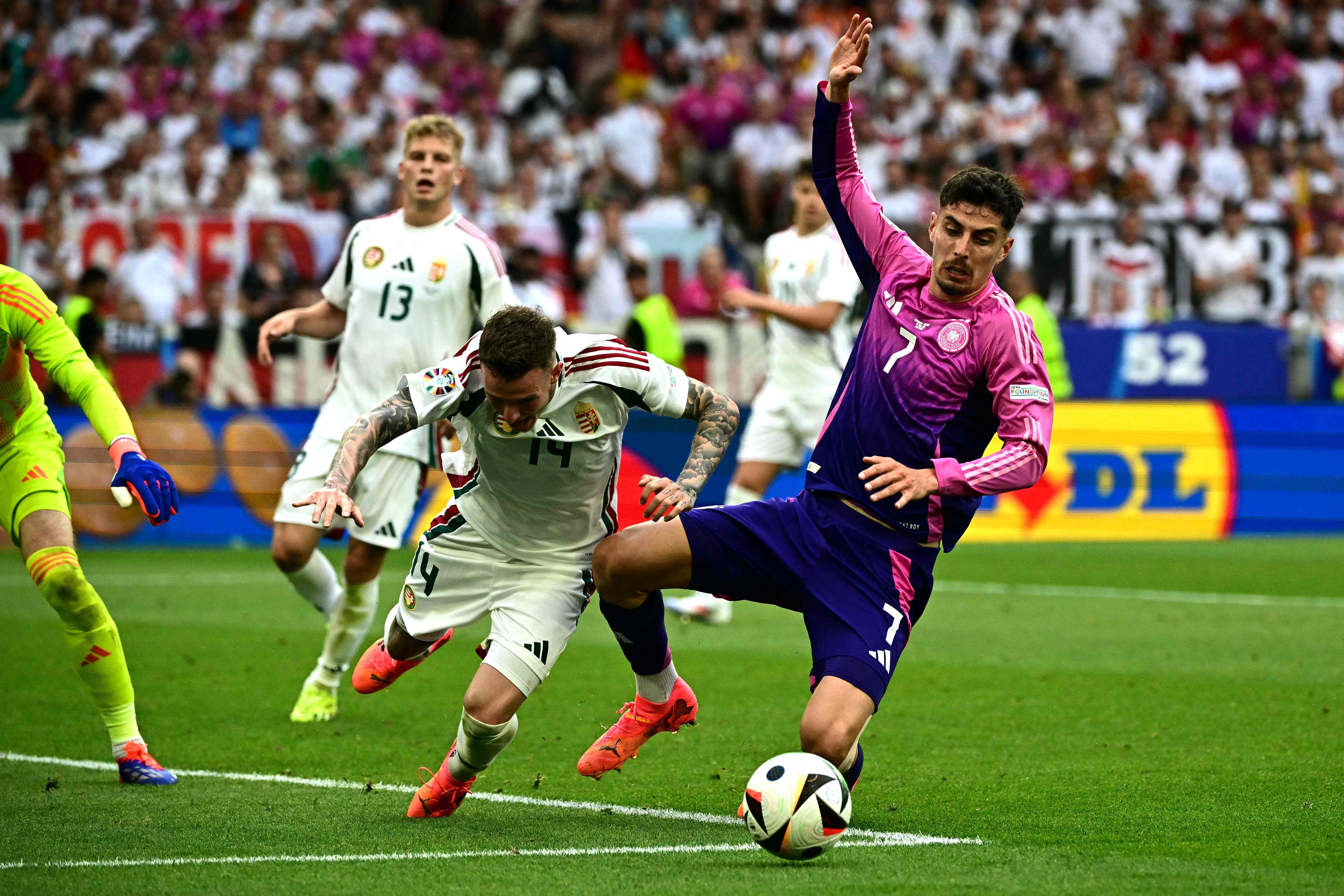 Hungary's defender #14 Bendeguz Bolla (C) fights for the ball with Germany's forward #07 Kai Havertz (R) during the UEFA Euro 2024 Group A football match between Germany and Hungary at the Stuttgart Arena in Stuttgart on June 19, 2024. (Photo by Tobias SCHWARZ / AFP)