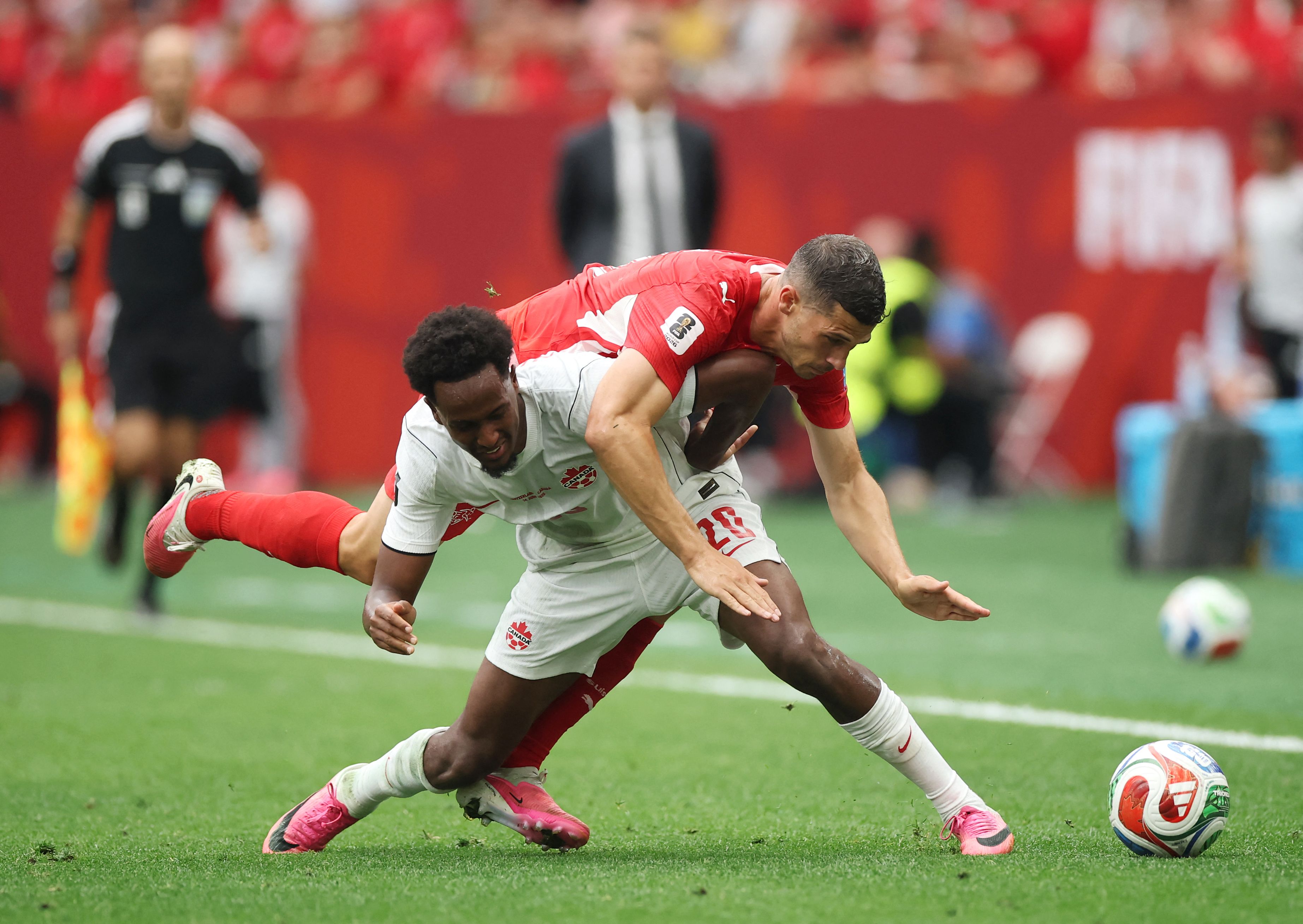 VANCOUVER, BRITISH COLUMBIA - JUNE 24: Remo Freuler #8 of Switzerland and Ali Ahmed #20 of Canada compete for the ball during the FIFA World Cup 2026 Group B match between Switzerland and Canada at BC Place Vancouver on June 24, 2026 in Vancouver, British Columbia.   Alex Grimm/Getty Images/AFP (Photo by ALEX GRIMM / GETTY IMAGES NORTH AMERICA / Getty Images via AFP)
