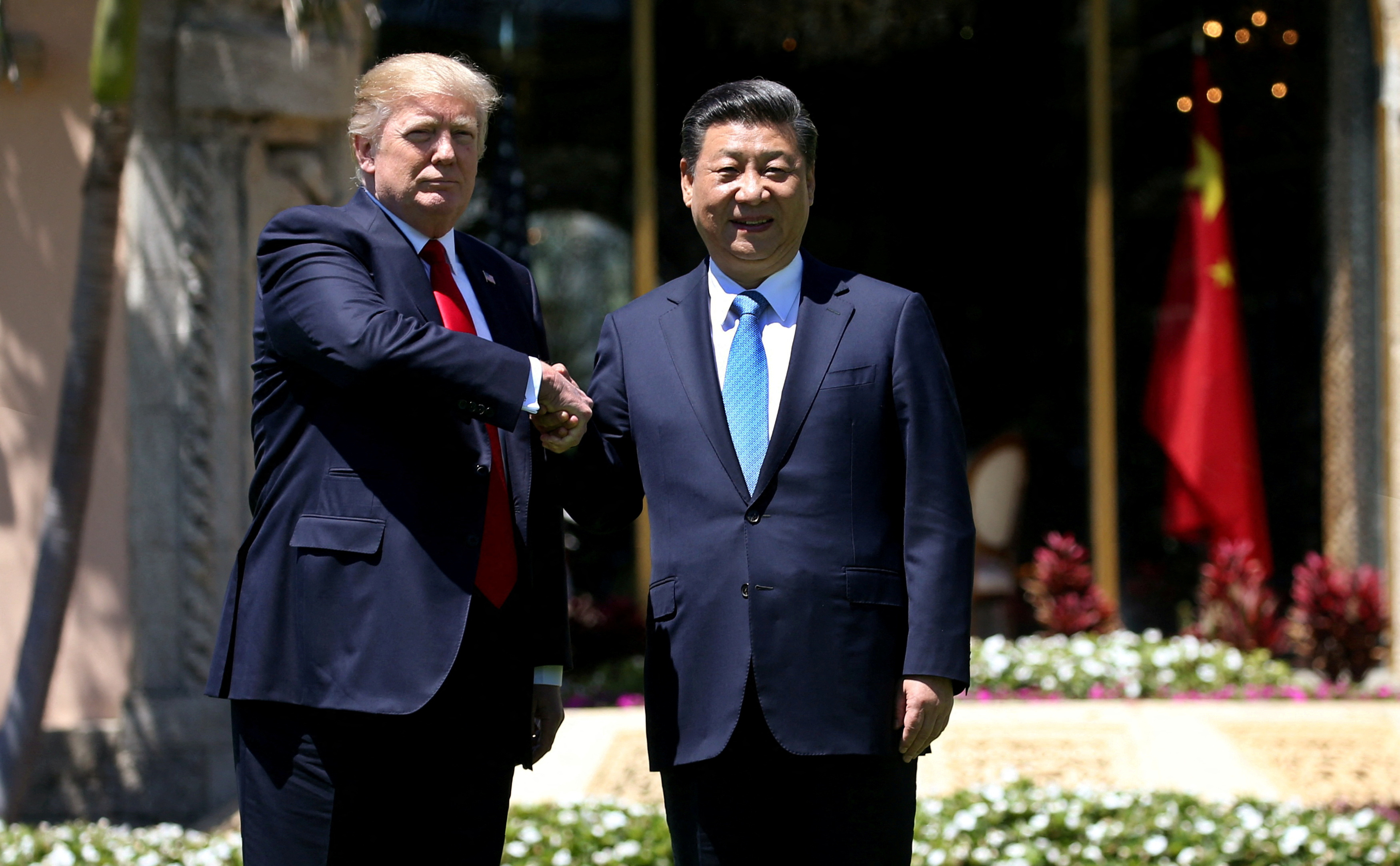 FILE PHOTO: U.S. President Donald Trump (L) and China's President Xi Jinping shake hands while walking at Mar-a-Lago estate after a bilateral meeting in Palm Beach, Florida, U.S., April 7, 2017. REUTERS/Carlos Barria/File Photo