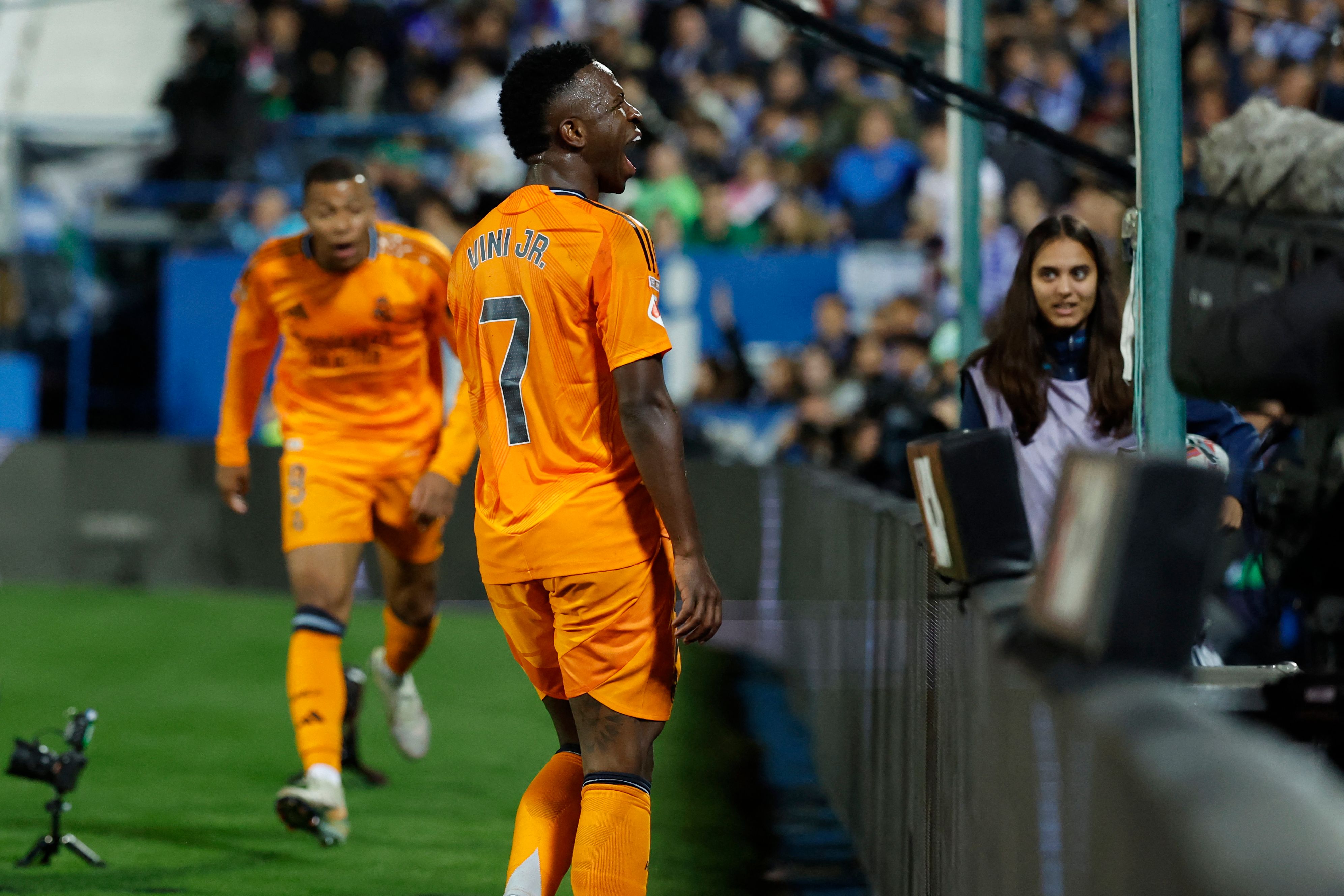 Real Madrid's Brazilian forward #07 Vinicius Junior celebrates the opening goal scored by Real Madrid's French forward #09 Kylian Mbappe (L) during the Spanish league football match between Club Deportivo Leganes SAD and Real Madrid CF at the Estadio Municipal Butarque in Leganes on November 24, 2024. (Photo by OSCAR DEL POZO / AFP)