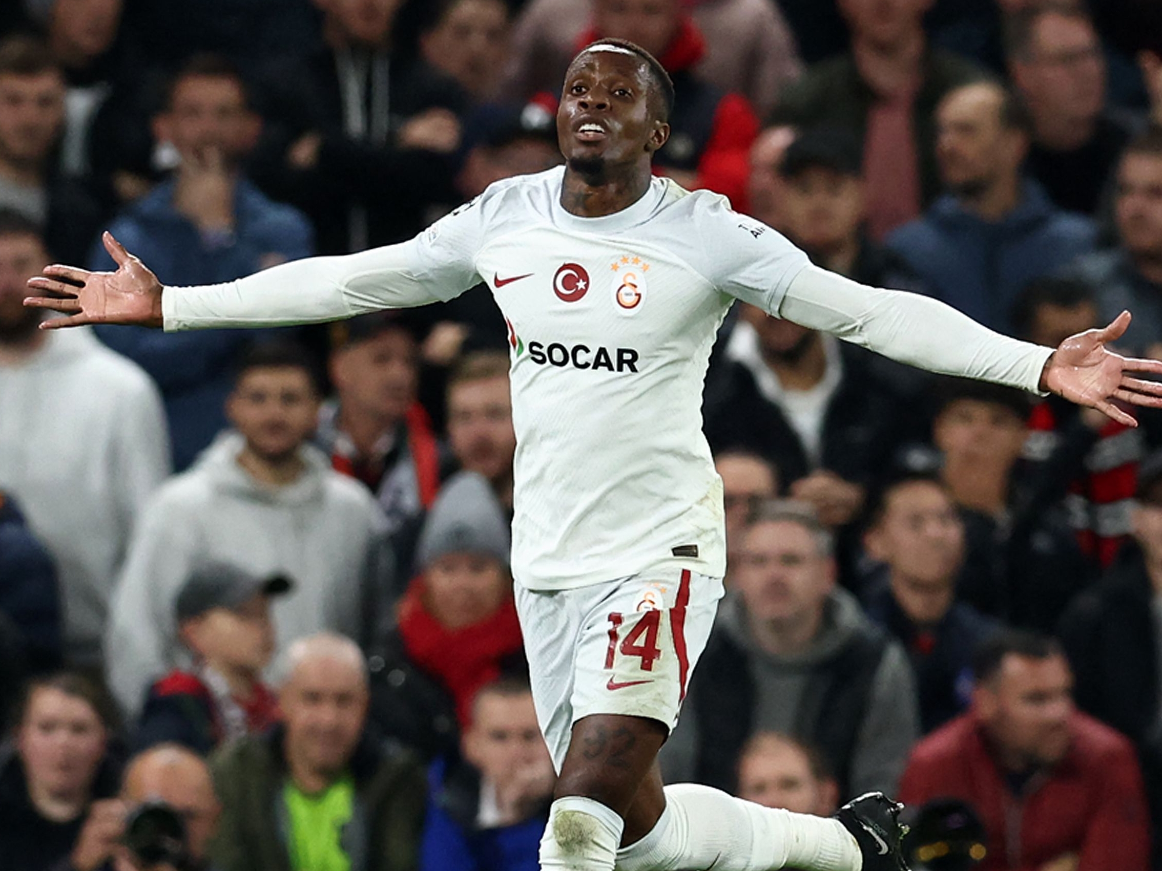 Galatasaray's Ivorian forward #14 Wilfred Zaha celebrates after scoring the equalising goal during the UEFA Champions league group A football match between Manchester United and Galatasaray at Old Trafford stadium in Manchester, north west England, on October 3, 2023. (Photo by Darren Staples / AFP)