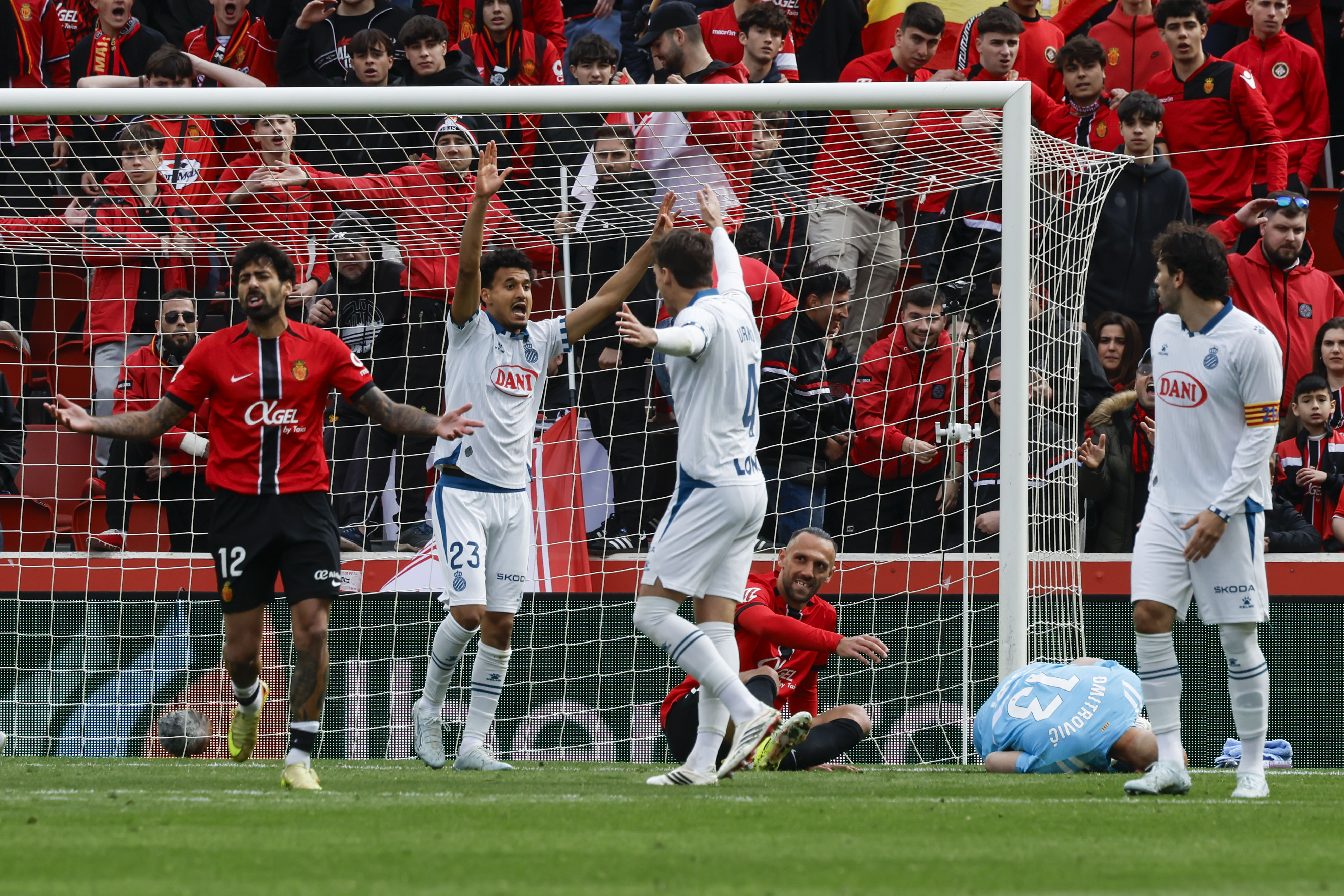 PALMA DE MALLORCA, 15/03/2026.- El jugador del Mallorca Samu Costa (i) se lamenta ante los jugadores Omar El Hilali (2i) y Urko (3i) del Espanyol durante el partido de LaLiga entre El Real Mallorca y El Espanyol que se disputa, este domingo, en Son Moix. EFE/ Cati Cladera
