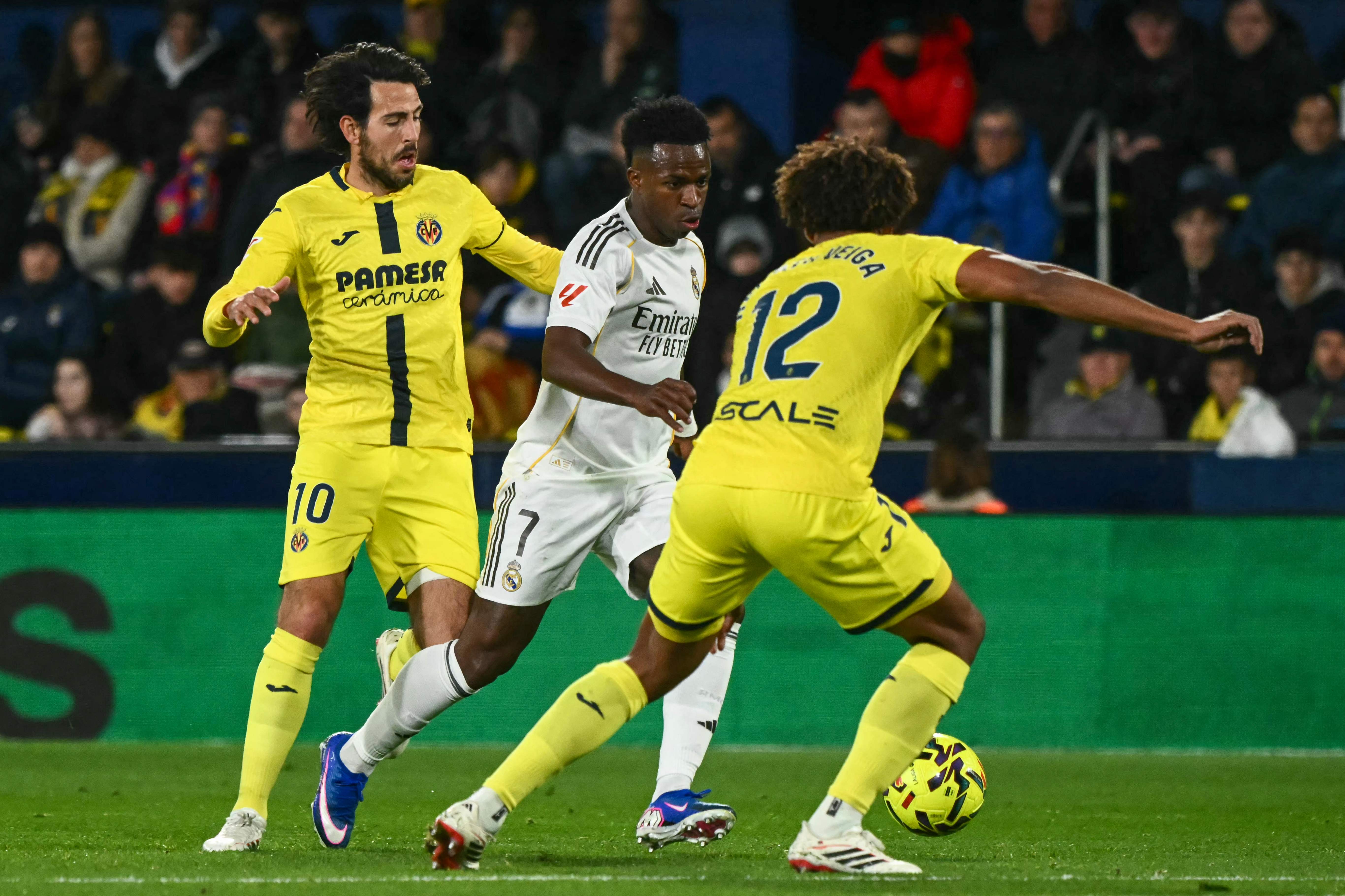 Real Madrid's Brazilian forward #07 Vinicius Junior (C) is challenged by Villarreal's Portuguese defender #12 Renato Veiga (R) and Villarreal's Spanish midfielder #10 Daniel Parejo during the Spanish league football match between Villarreal CF and Real Madrid CF at La Ceramica Stadium in Vila-Real on January 24, 2026. (Photo by JOSE JORDAN / AFP)