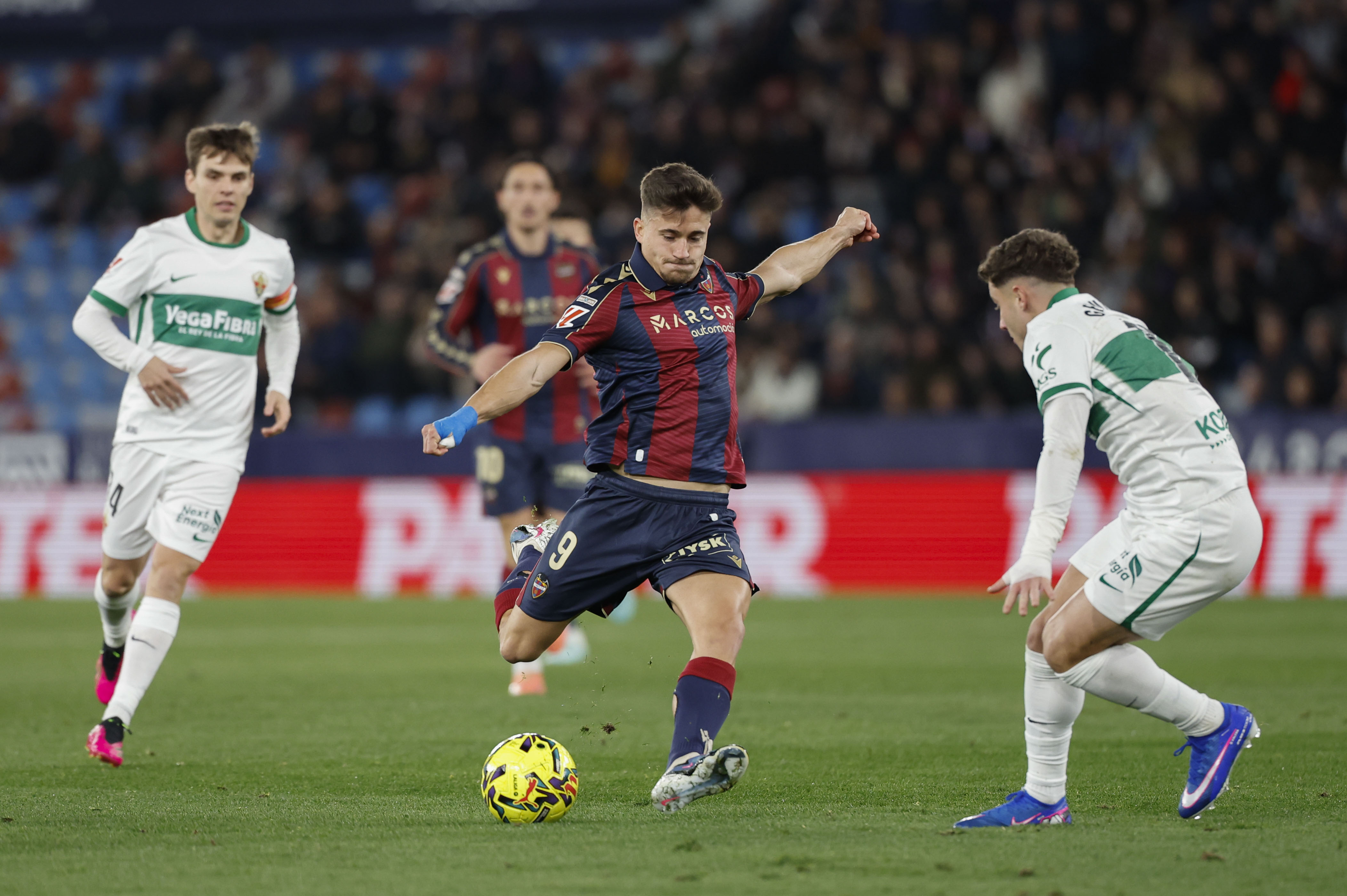 VALENCIA, 23/01/2026.- El centrocampista del Levante Iván Romero (c) dispara a puerta durante el partido de la jornada 21 de LaLiga que Levante UD y Elche CF disputan hoy viernes en el estadio Ciutat de Valencia. EFE/Ana Escobar
