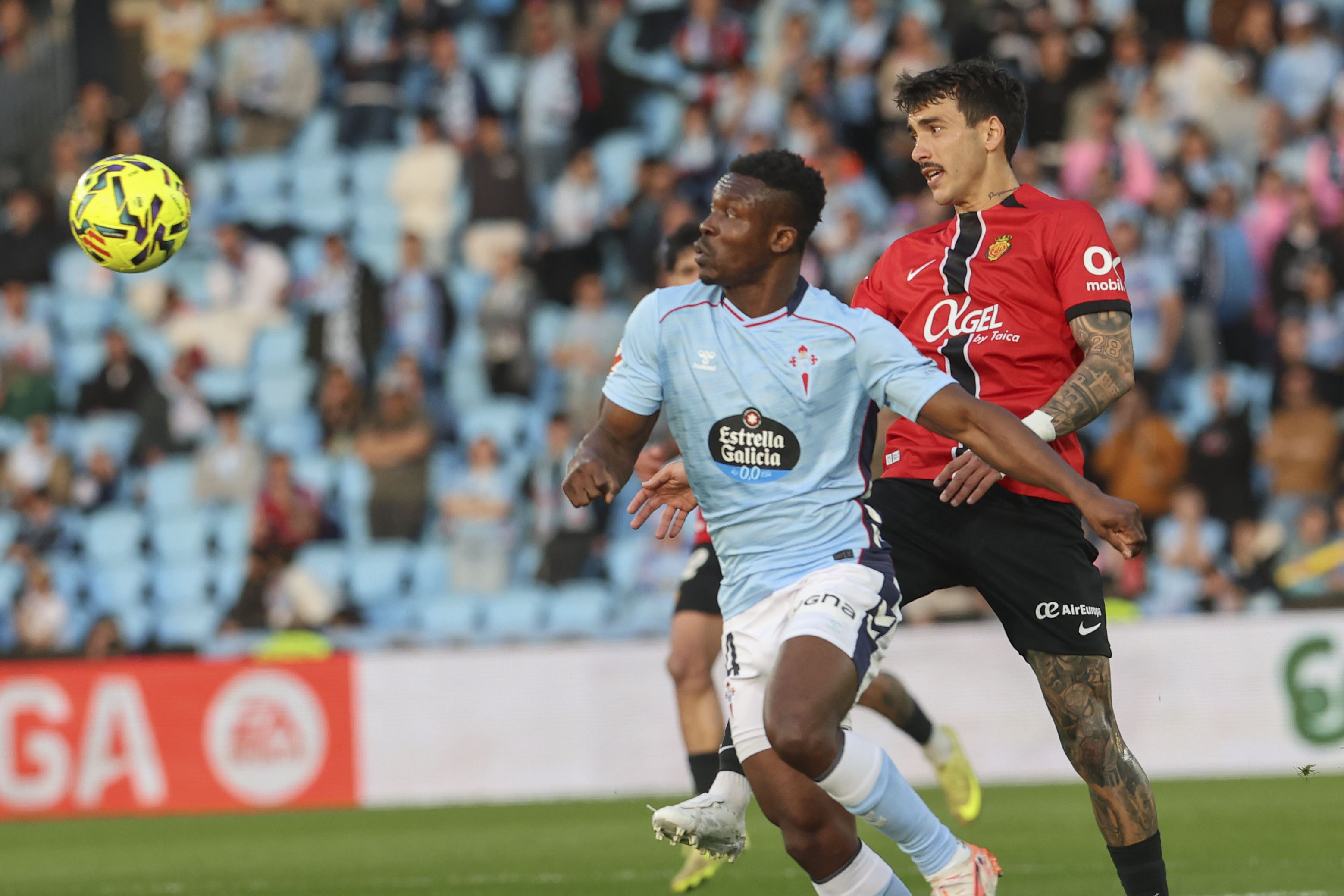 VIGO (GALICIA), 22/02/2026.- El defensa del Celta Joseph Aidoo (i) pelea un balón ante el centrocampista del Mallorca Antonio Sánchez durante el partido de la jornada 25 de LaLiga EA Sports que Celta de Vigo y RCD Mallorca disputan este domingo, en el Estadio de Balaidos. EFE/ Salvador Sas