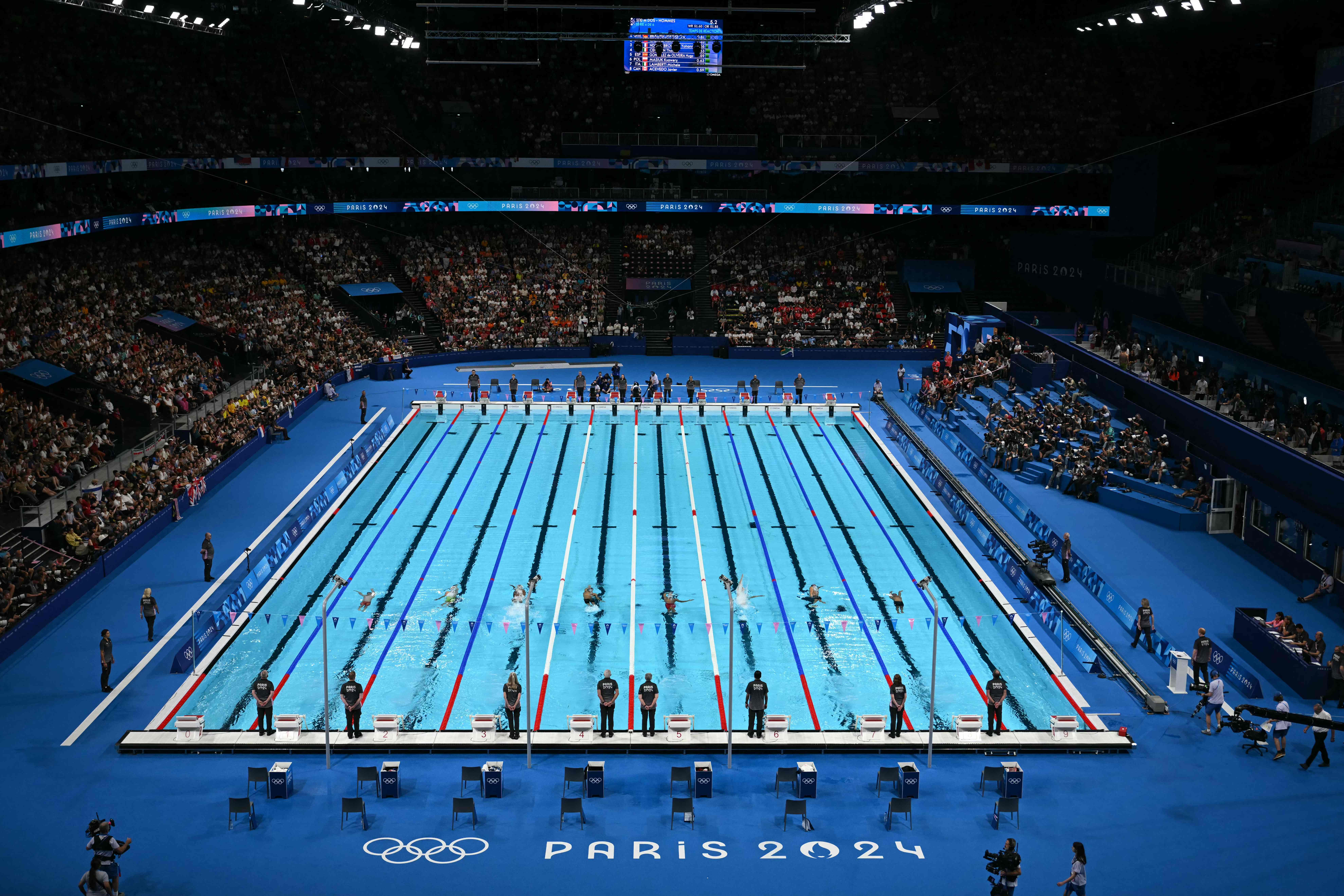 Swimmers compete in a heat of the men's 100m backstroke swimming event during the Paris 2024 Olympic Games at the Paris La Defense Arena in Nanterre, west of Paris, on July 28, 2024. (Photo by Jonathan NACKSTRAND / AFP)