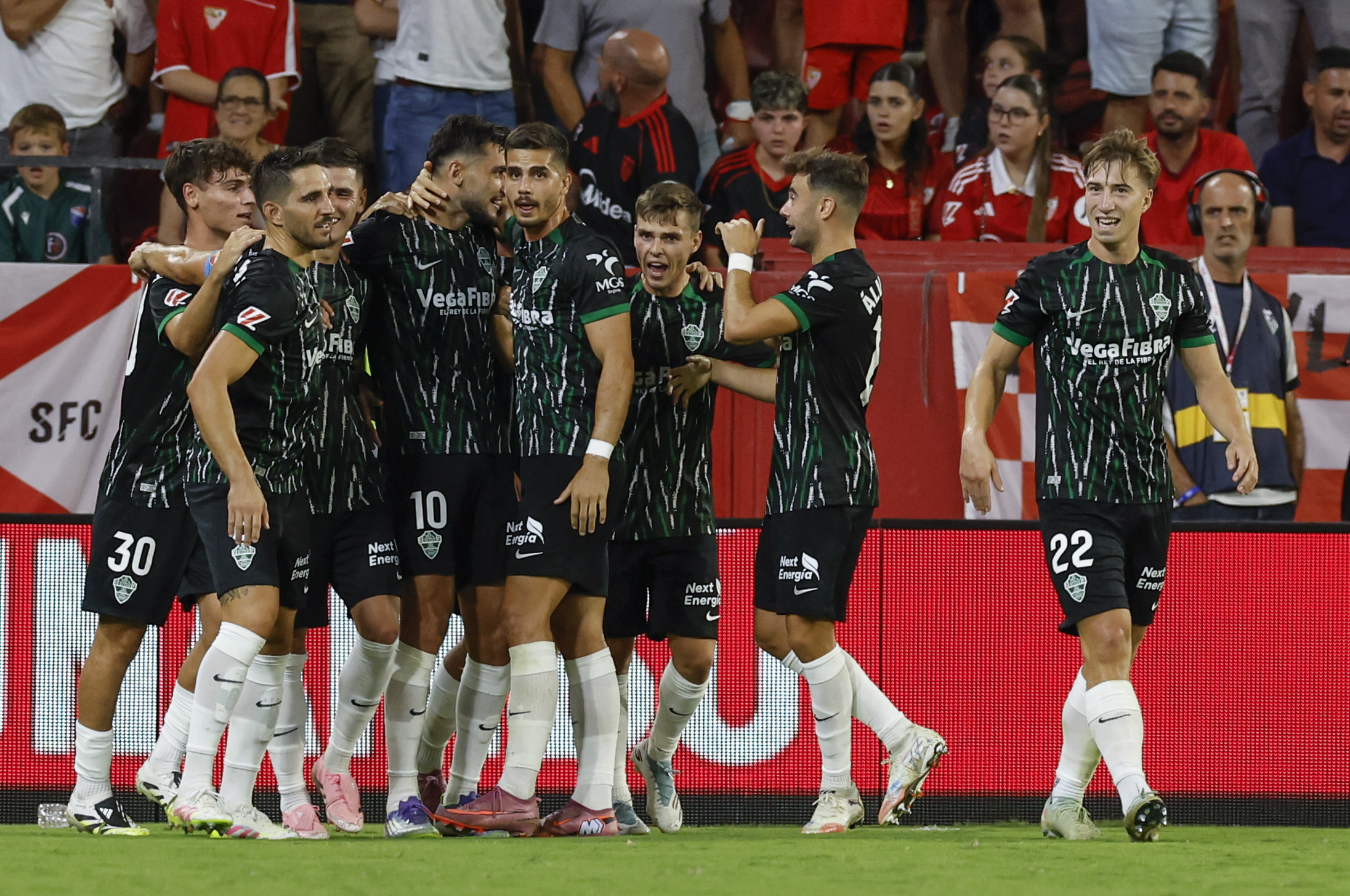 SEVILLA, 12/09/2025.- El delantero del Elche Rafa Mir (3-i) celebra con sus compañeros tras marcar el 1-2, durante el partido de la cuarta jornadade LaLiga EA Sports que Sevilla FC y Elche CF disputan este viernes en el estadio Ramón Sánchez-Pizjuán de la capital andaluza. EFE/Julio Muñoz
