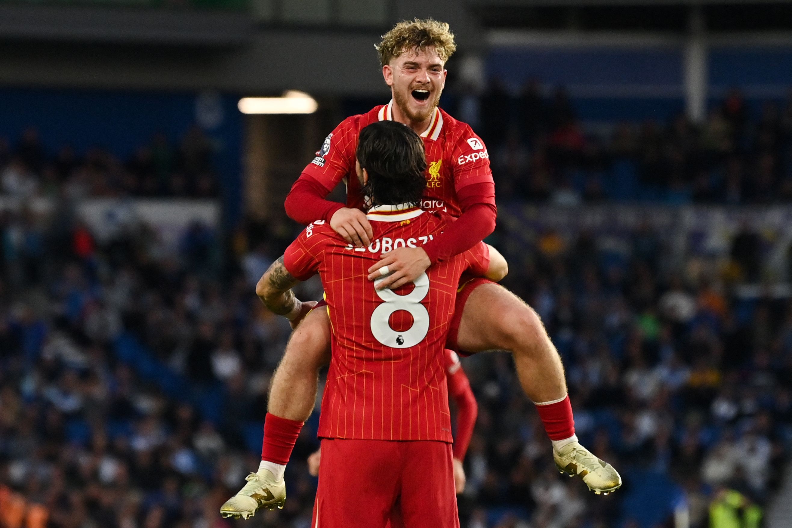 Liverpool's Hungarian midfielder #08 Dominik Szoboszlai celebrates with Liverpool's English midfielder #19 Harvey Elliott after scoring his team second goal during the English Premier League football match between Brighton and Hove Albion and Liverpool at the American Express Community Stadium in Brighton, southern England on May 19, 2025. (Photo by Glyn KIRK / AFP) / RESTRICTED TO EDITORIAL USE. No use with unauthorized audio, video, data, fixture lists, club/league logos or 'live' services. Online in-match use limited to 120 images. An additional 40 images may be used in extra time. No video emulation. Social media in-match use limited to 120 images. An additional 40 images may be used in extra time. No use in betting publications, games or single club/league/player publications. / 