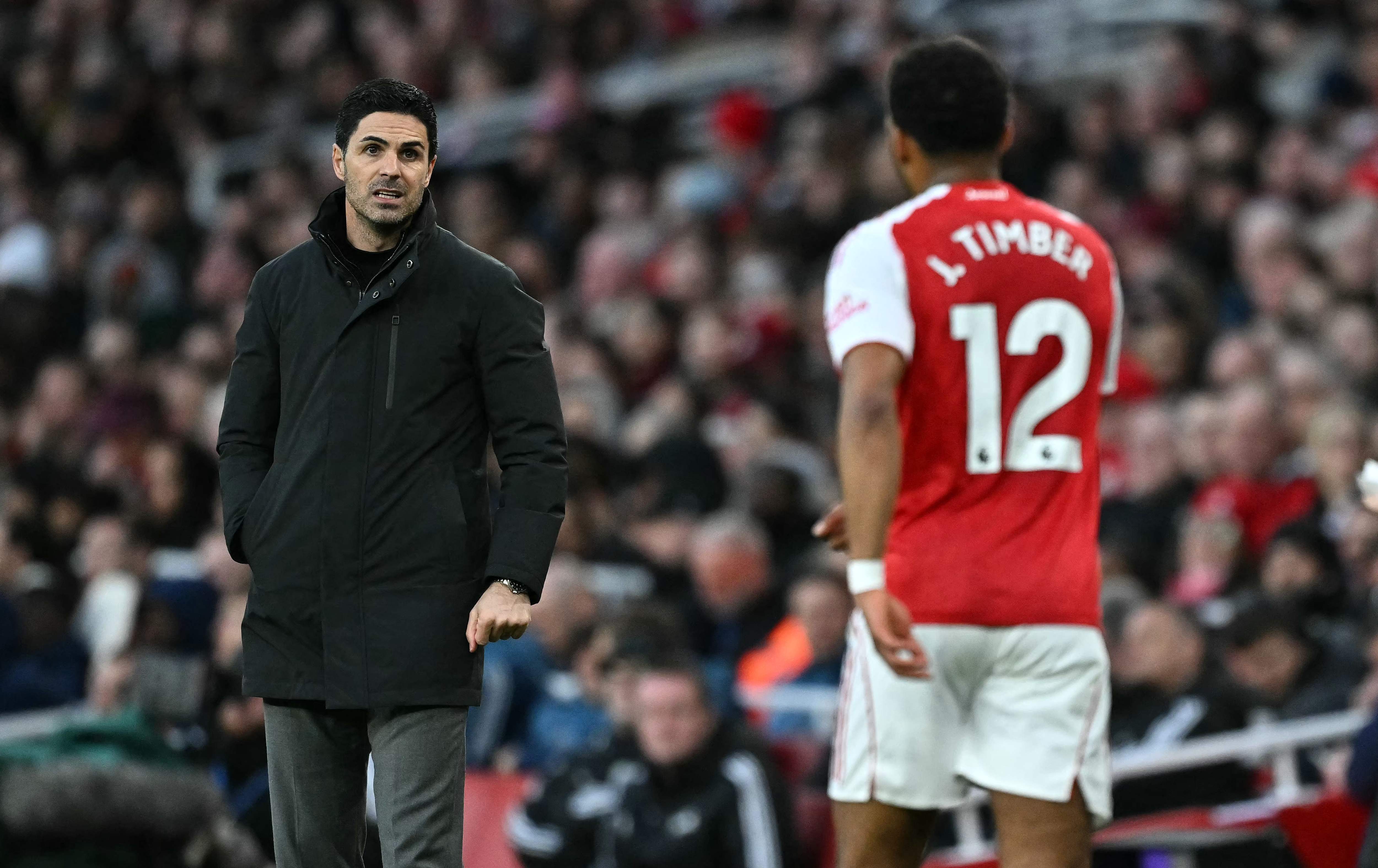 Arsenal's Dutch defender #12 Jurrien Timber (R) talks with Arsenal's Spanish manager Mikel Arteta before being substituted off during the English Premier League football match between Arsenal and Everton at the Emirates Stadium in London on March 14, 2026. (Photo by Ben STANSALL / AFP) / RESTRICTED TO EDITORIAL USE. No use with unauthorized audio, video, data, fixture lists, club/league logos or 'live' services. Online in-match use limited to 120 images. An additional 40 images may be used in extra time. No video emulation. Social media in-match use limited to 120 images. An additional 40 images may be used in extra time. No use in betting publications, games or single club/league/player publications. / 