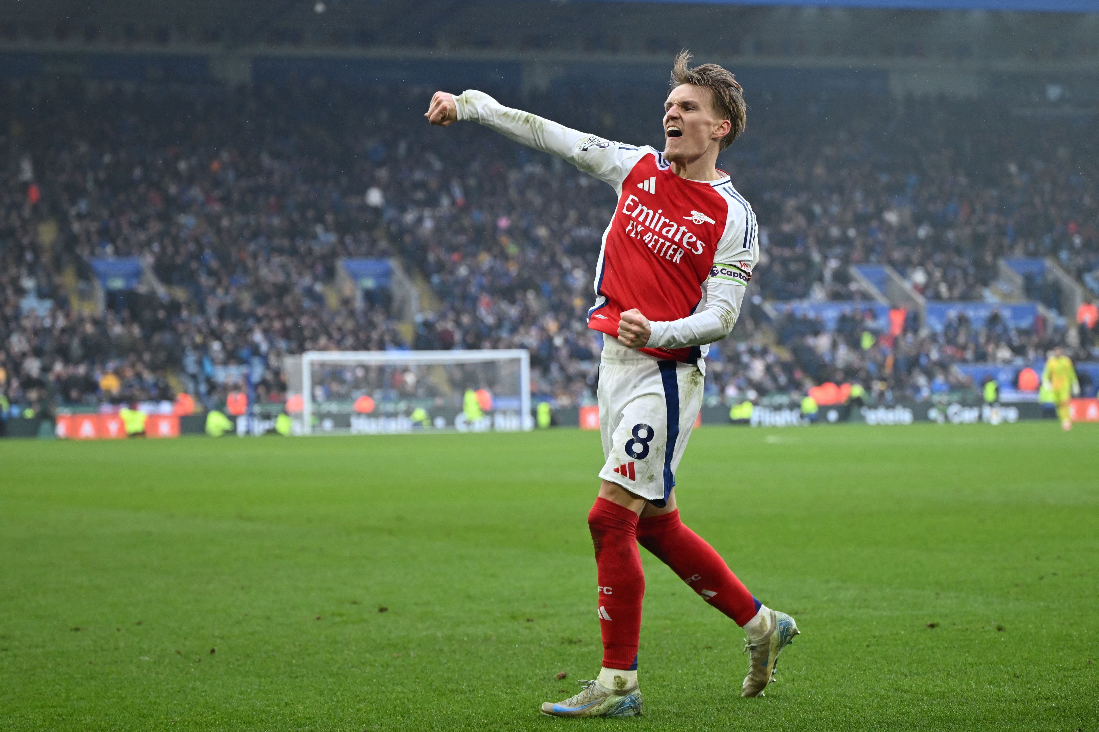 Arsenal's Norwegian midfielder #08 Martin Odegaard celebrates their second goal during the English Premier League football match between Leicester City and Arsenal at King Power Stadium in Leicester, central England on February 15, 2025. (Photo by JUSTIN TALLIS / AFP) / RESTRICTED TO EDITORIAL USE. No use with unauthorized audio, video, data, fixture lists, club/league logos or 'live' services. Online in-match use limited to 120 images. An additional 40 images may be used in extra time. No video emulation. Social media in-match use limited to 120 images. An additional 40 images may be used in extra time. No use in betting publications, games or single club/league/player publications. / 