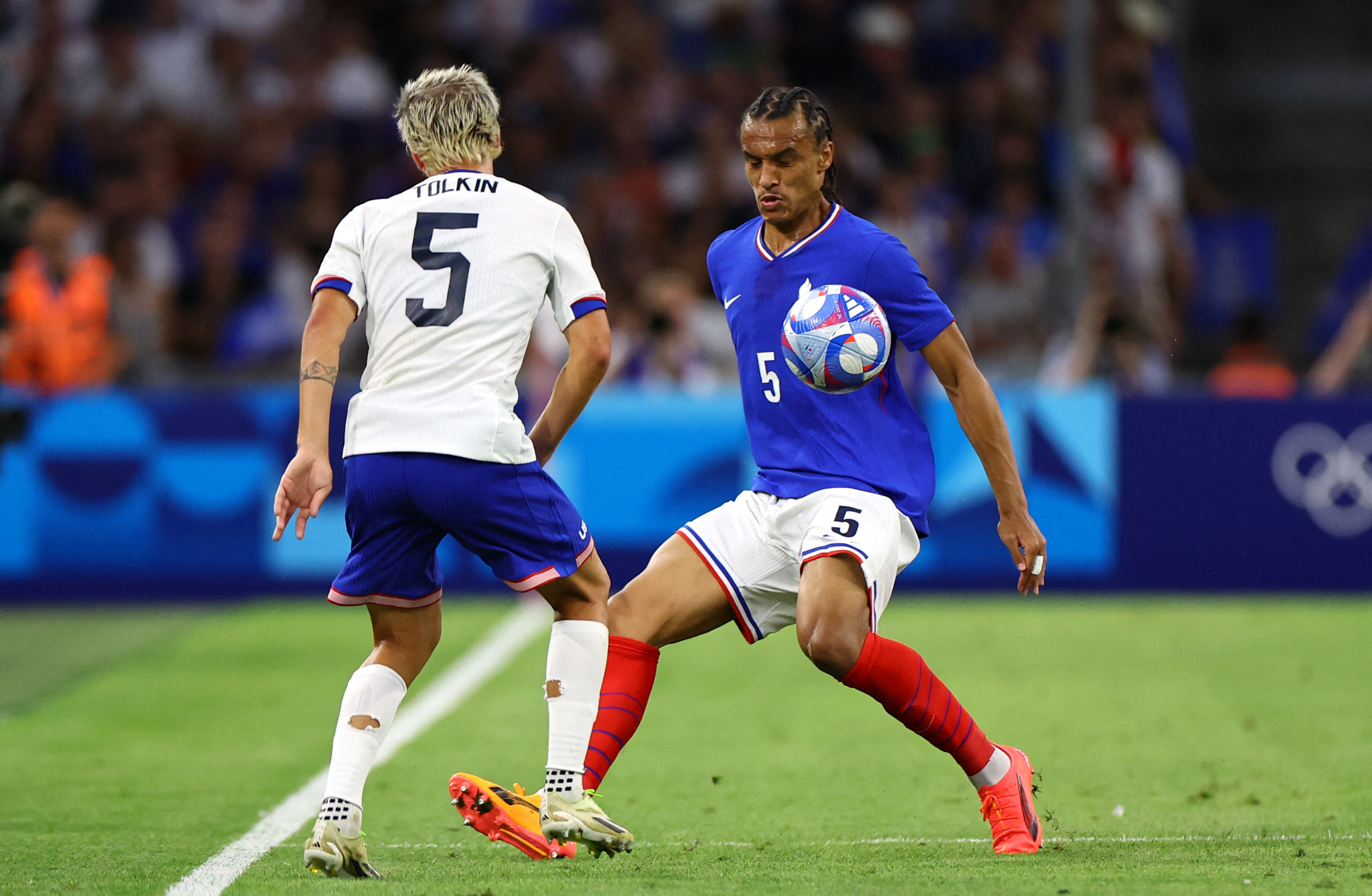 Paris 2024 Olympics - Football - Men's Group A - France vs United States of America - Marseille Stadium, Marseille, France - July 24, 2024. Kiliann Sildillia of France in action with John Tolkin of United States. REUTERS/Luisa Gonzalez