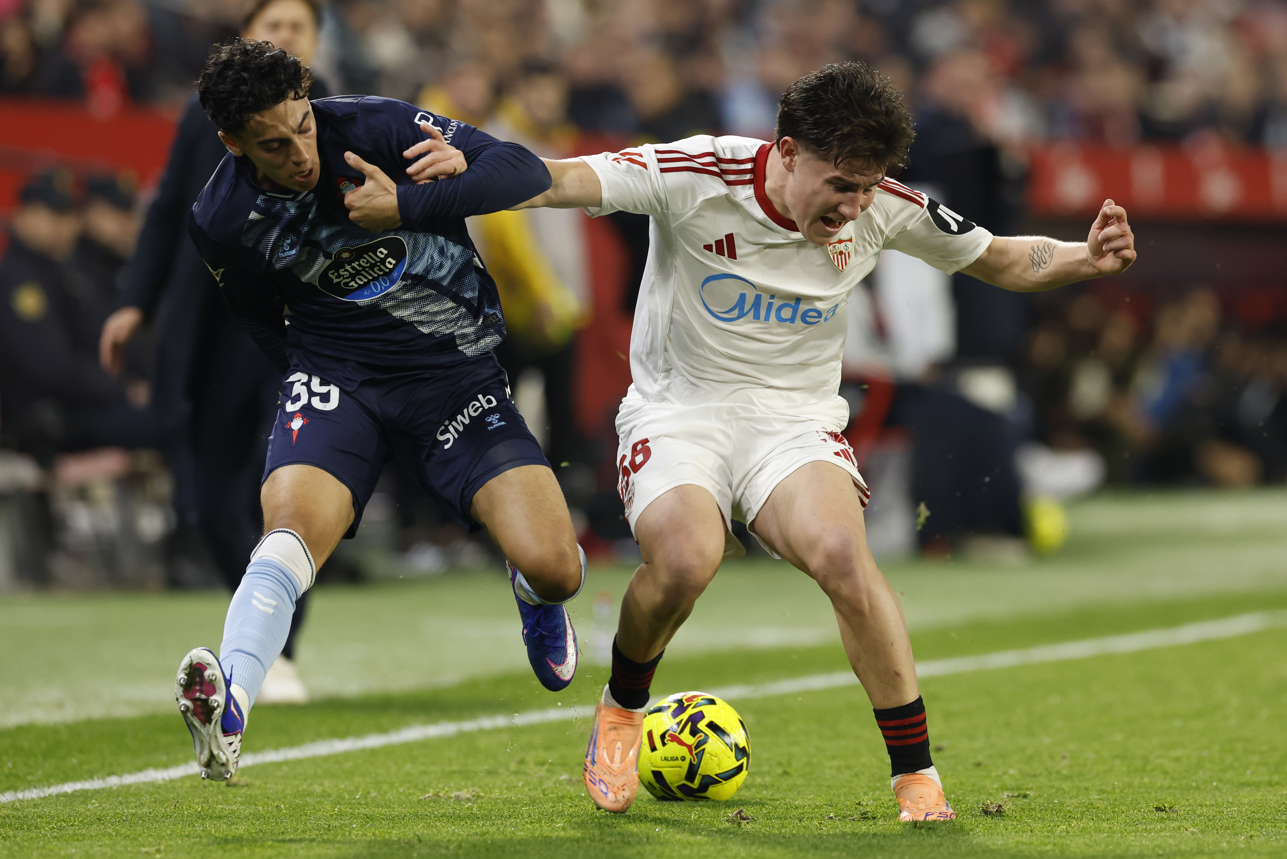 SEVILLA, 12/01/2026.- El centrocampista del Sevilla, Oso (d), disputa el balón ante el jugador noruego del Celta, Jones El-Abdellaoui, durante el encuentro correspondiente a la jornada 19 de Laliga EA Sports que disputan hoy lunes Sevilla y Celta en el estadio Sánchez Pizjuán, en la capital andaluza. EFE / Julio Muñoz.
