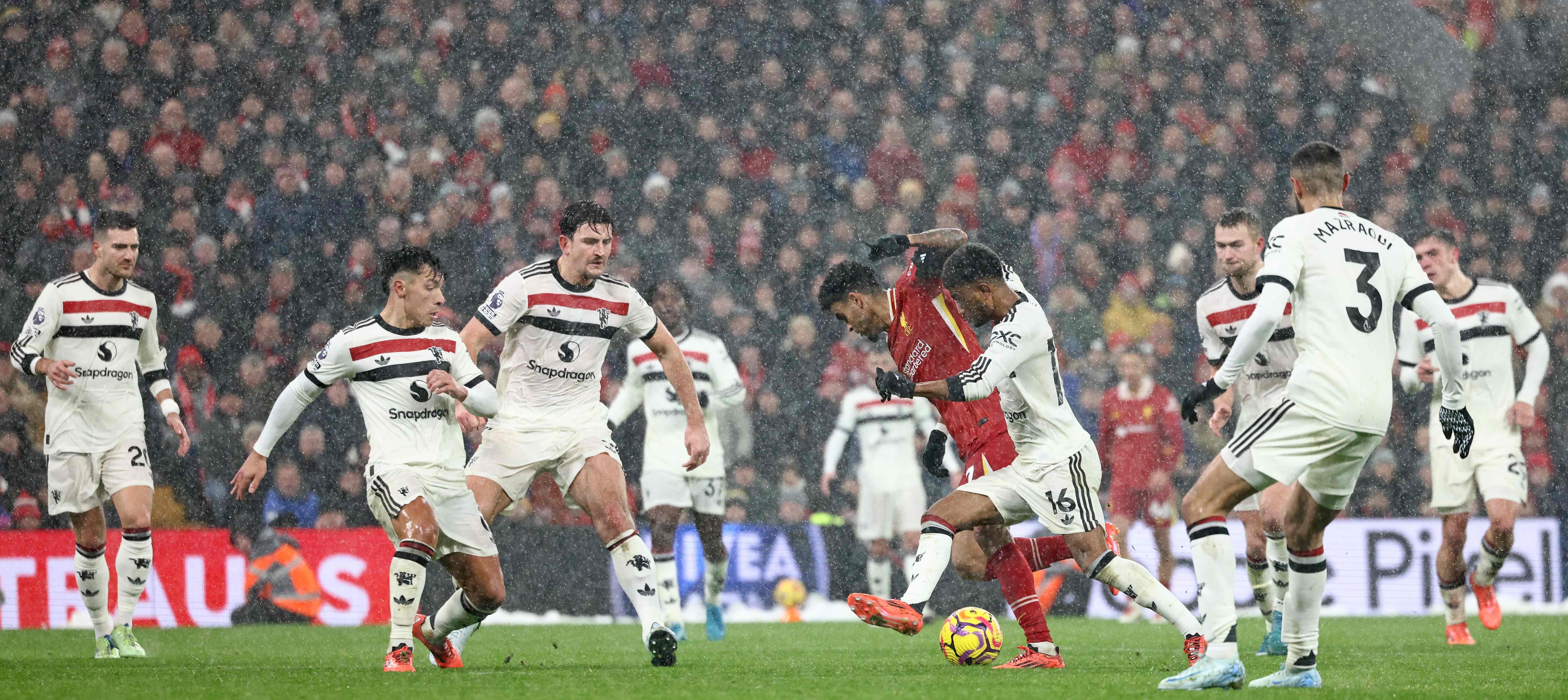 Liverpool's Colombian midfielder #07 Luis Diaz (C) is surrounded by United players during the English Premier League football match between Liverpool and Manchester United at Anfield in Liverpool, north west England on January 5, 2025. (Photo by Darren Staples / AFP) / RESTRICTED TO EDITORIAL USE. No use with unauthorized audio, video, data, fixture lists, club/league logos or 'live' services. Online in-match use limited to 120 images. An additional 40 images may be used in extra time. No video emulation. Social media in-match use limited to 120 images. An additional 40 images may be used in extra time. No use in betting publications, games or single club/league/player publications. / 