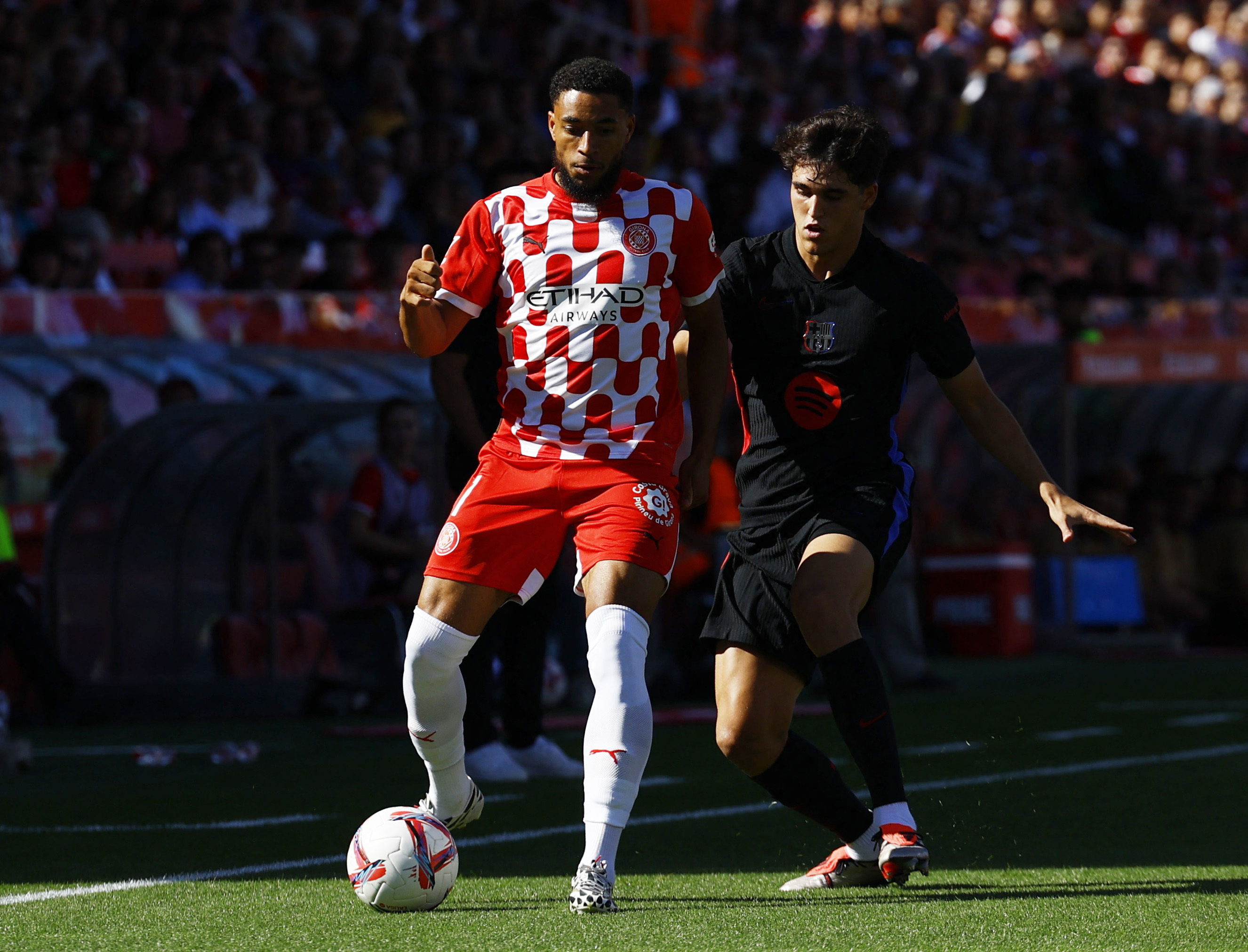 Soccer Football - LaLiga - Girona v FC Barcelona - Estadi Montilivi, Girona, Spain - September 15, 2024 Girona's Arnaut Danjuma in action with FC Barcelona's Pau Cubarsi REUTERS/Albert Gea