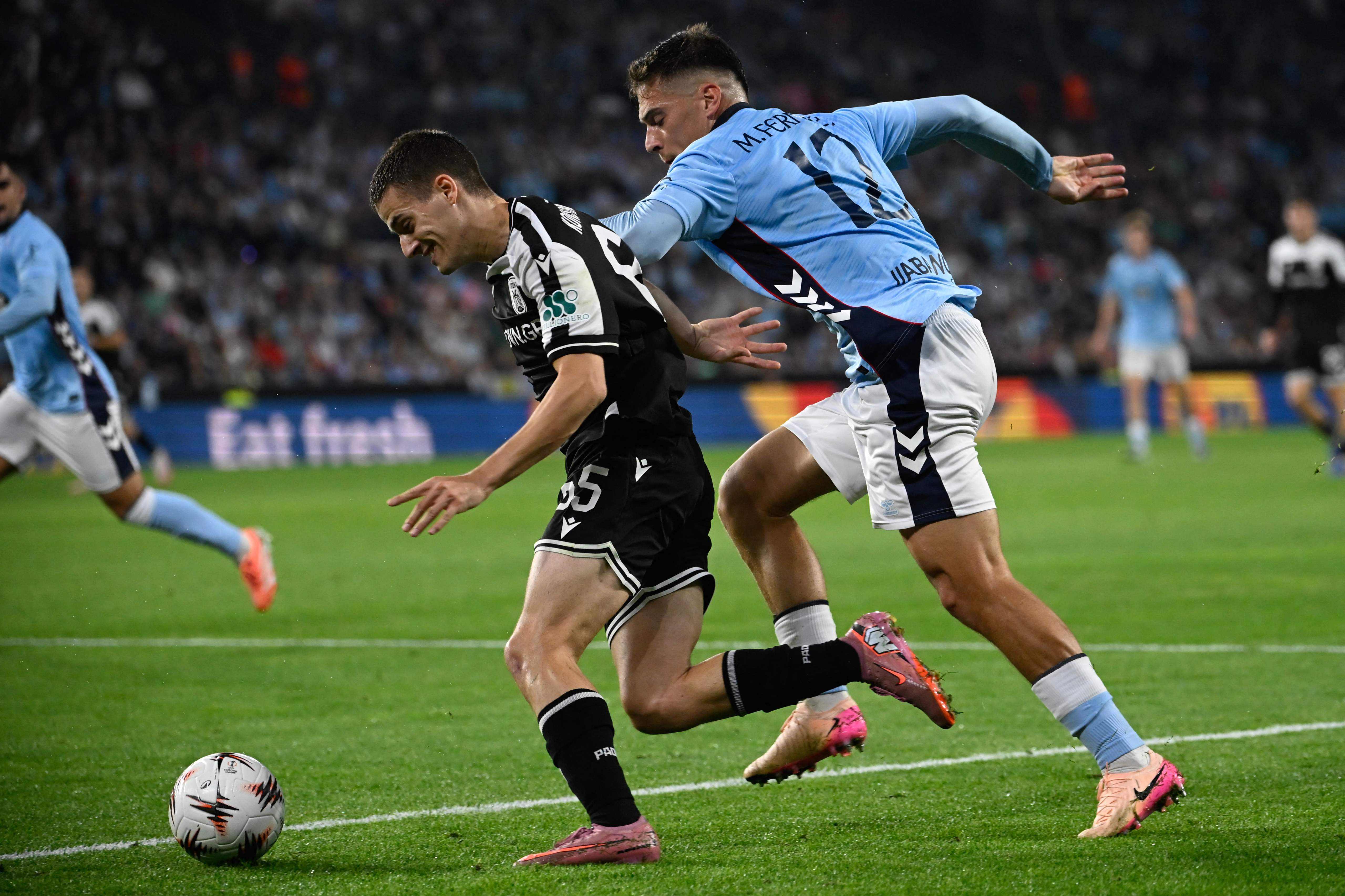 Celta Vigo's Spanish defender #12 Manu Fernandez (R) and PAOK's Greek midfielder #65 Giannis Konstantelias vie for the ball during the UEFA Europa League first round day 2 football match between RC Celta de Vigo and PAOK FC at Balaidos Stadium in Vigo on October 2, 2025. (Photo by Miguel RIOPA / AFP)