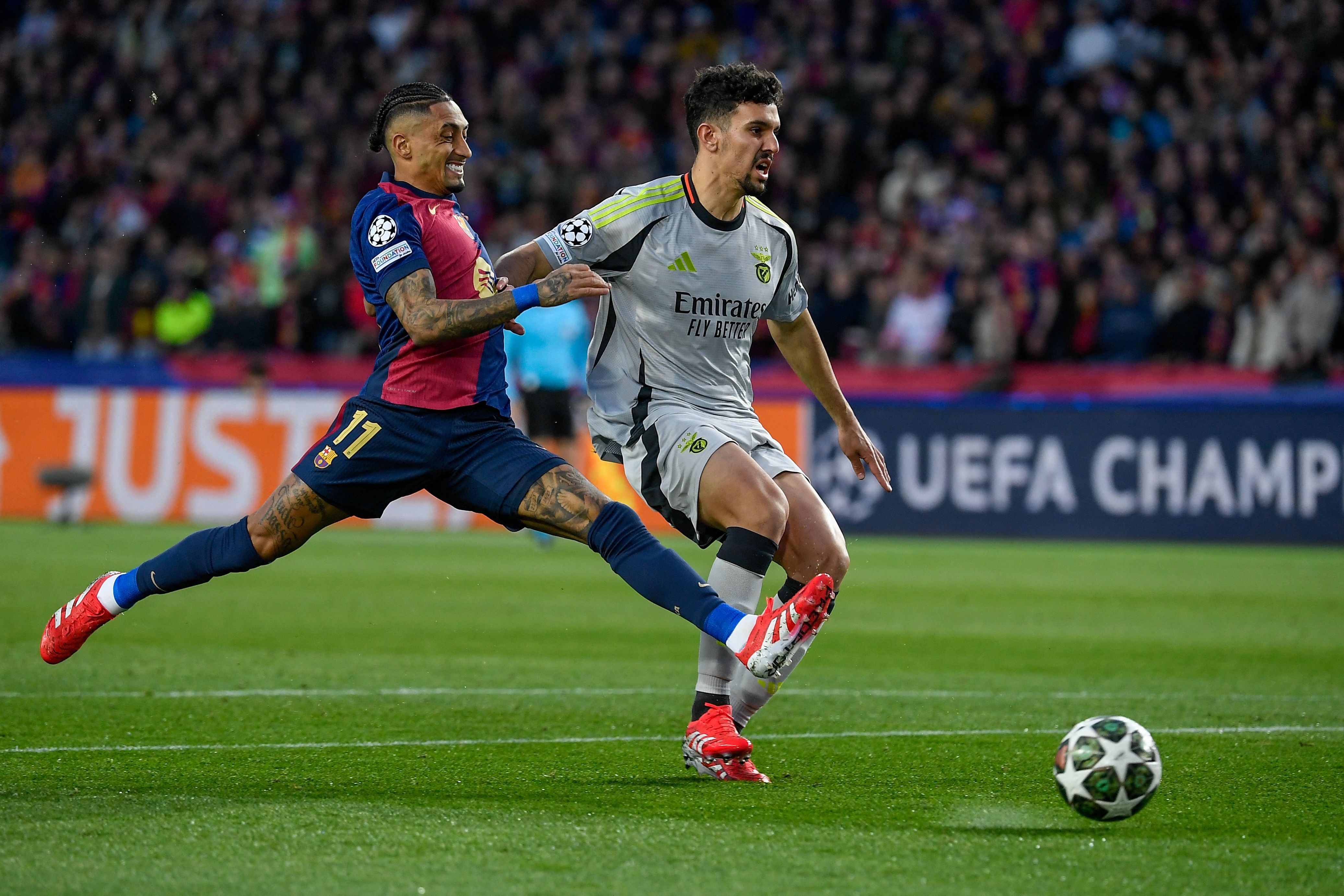 Barcelona's Brazilian forward #11 Raphinha (L) challenges Benfica's Portuguese defender #44 Tomas Araujo during the UEFA Champions League Round of 16 second leg football match between FC Barcelona and SL Benfica at the Estadi Olimpic Lluis Companys in Barcelona on March 11, 2025. (Photo by Josep LAGO / AFP)