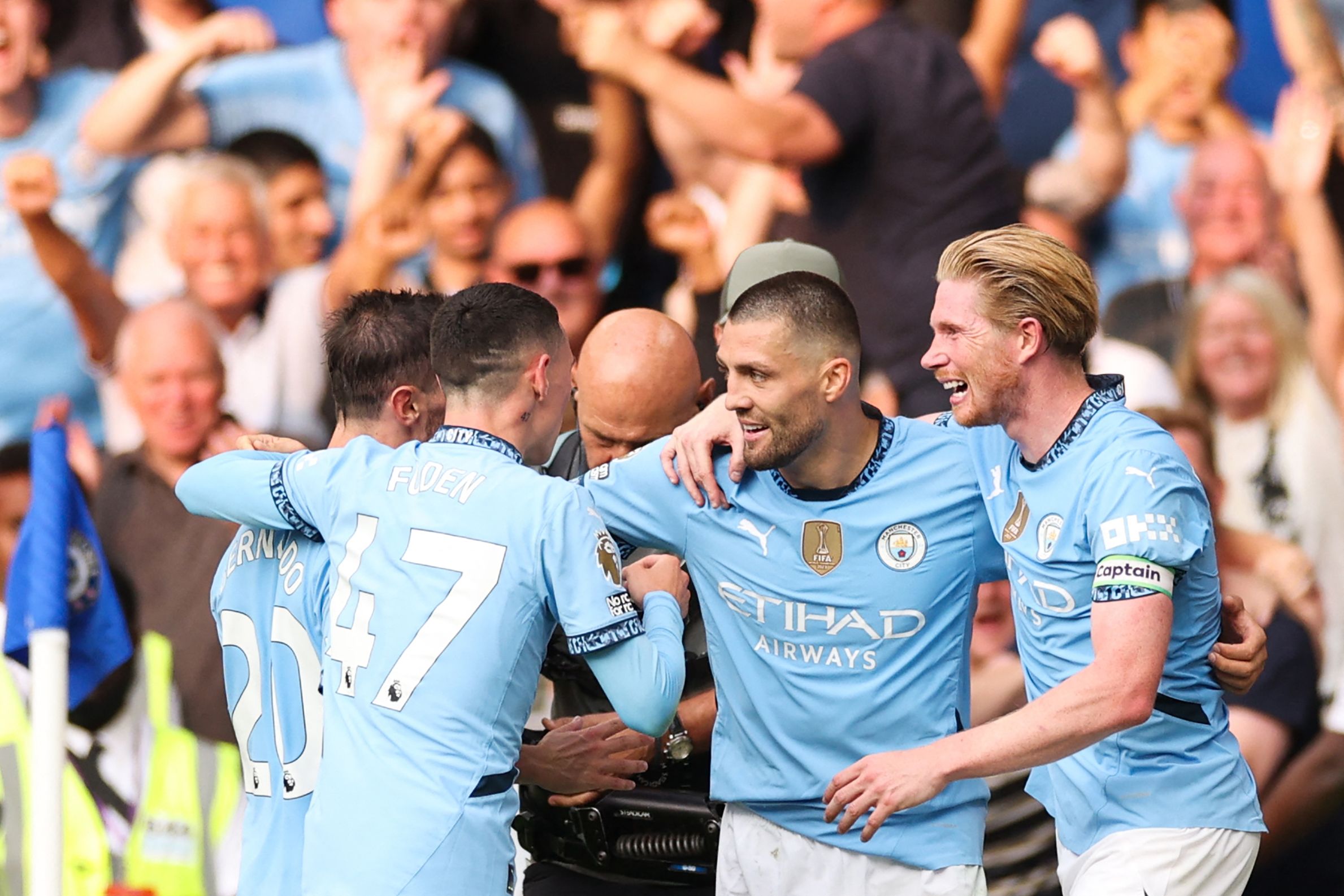 Manchester City's Croatian midfielder #08 Mateo Kovacic (2nd R) celebrates after scoring his team second goal during the English Premier League football match between Chelsea and Manchester City at Stamford Bridge in London on August 18, 2024. (Photo by Adrian DENNIS / AFP) / RESTRICTED TO EDITORIAL USE. No use with unauthorized audio, video, data, fixture lists, club/league logos or 'live' services. Online in-match use limited to 120 images. An additional 40 images may be used in extra time. No video emulation. Social media in-match use limited to 120 images. An additional 40 images may be used in extra time. No use in betting publications, games or single club/league/player publications. / 