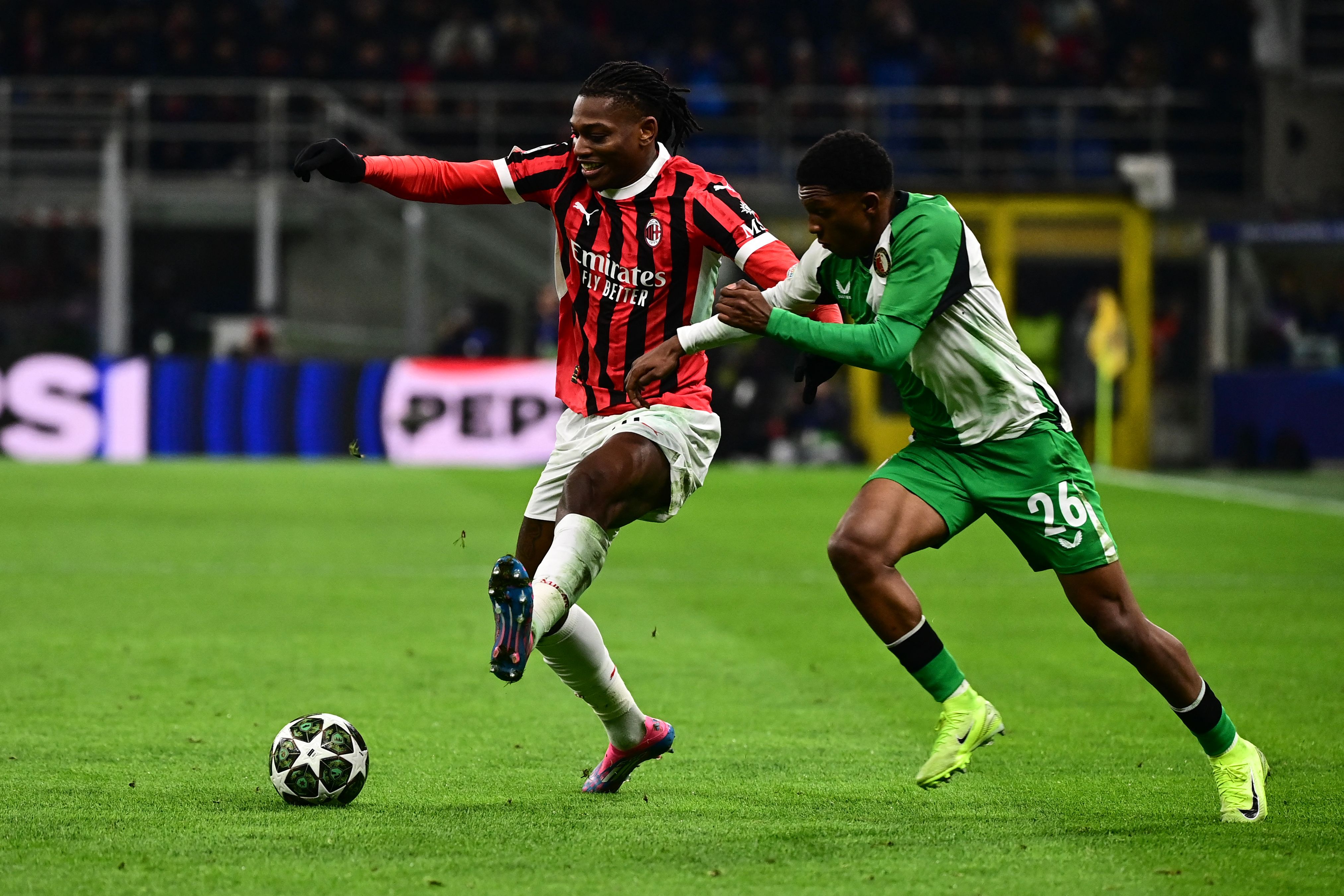 AC Milan's Portuguese forward #10 Rafael Leao fights for the ball with Feyenoord's Dutch defender #26 Givairo Read during the UEFA Champions League knockout round play-off second leg football match between AC Milan and Feyenoord at San Siro stadium in Milan, on February 18, 2025. (Photo by Piero CRUCIATTI / AFP)