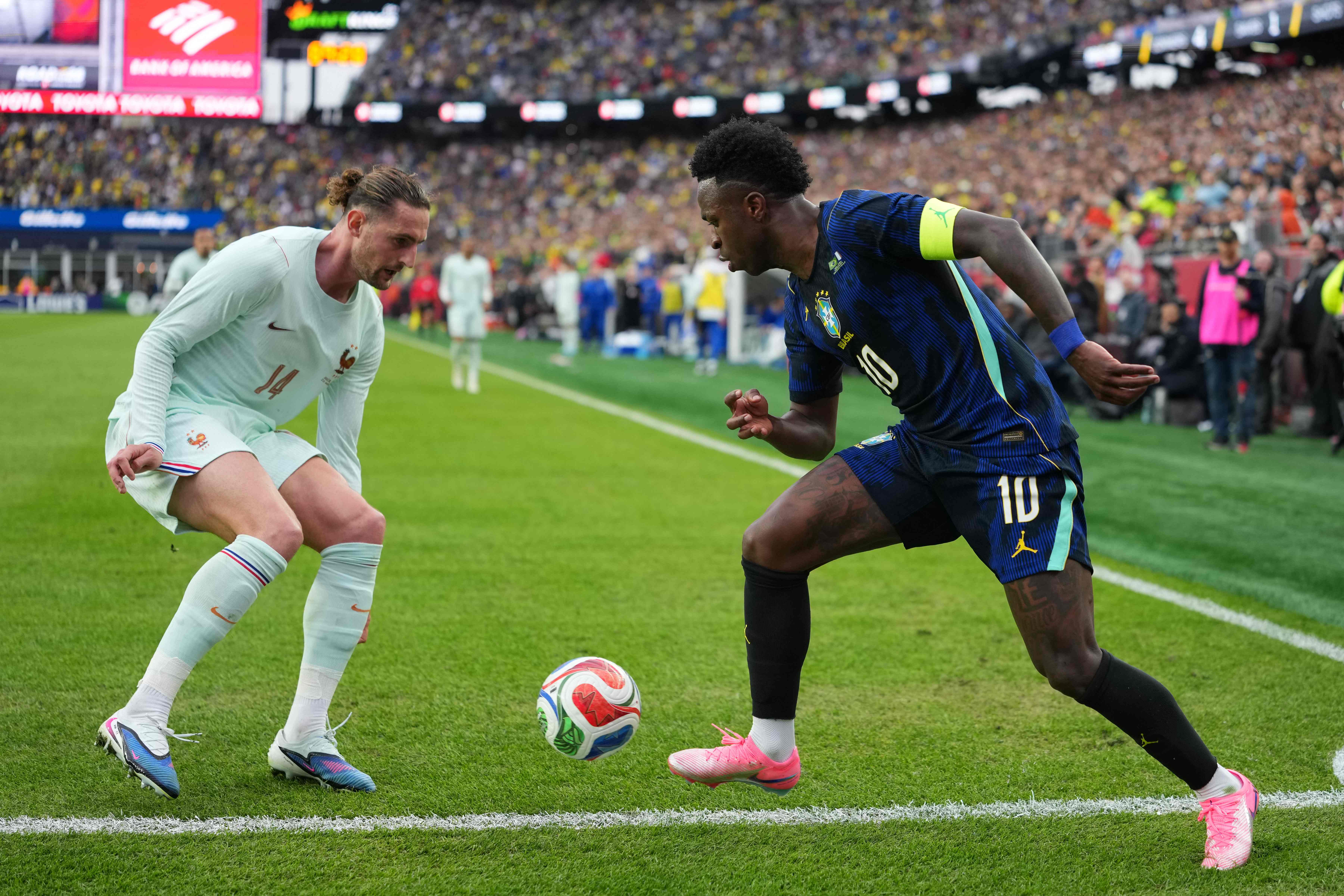 FOXBOROUGH, MASSACHUSETTS - MARCH 26: Vinicius Junior of Brazil runs with the ball against Adrien Rabiot of France during the international friendly match between Brazil and France at Gillette Stadium on March 26, 2026 in Foxborough, Massachusetts. Michael Owens/Getty Images/AFP (Photo by Michael Owens / GETTY IMAGES NORTH AMERICA / Getty Images via AFP)