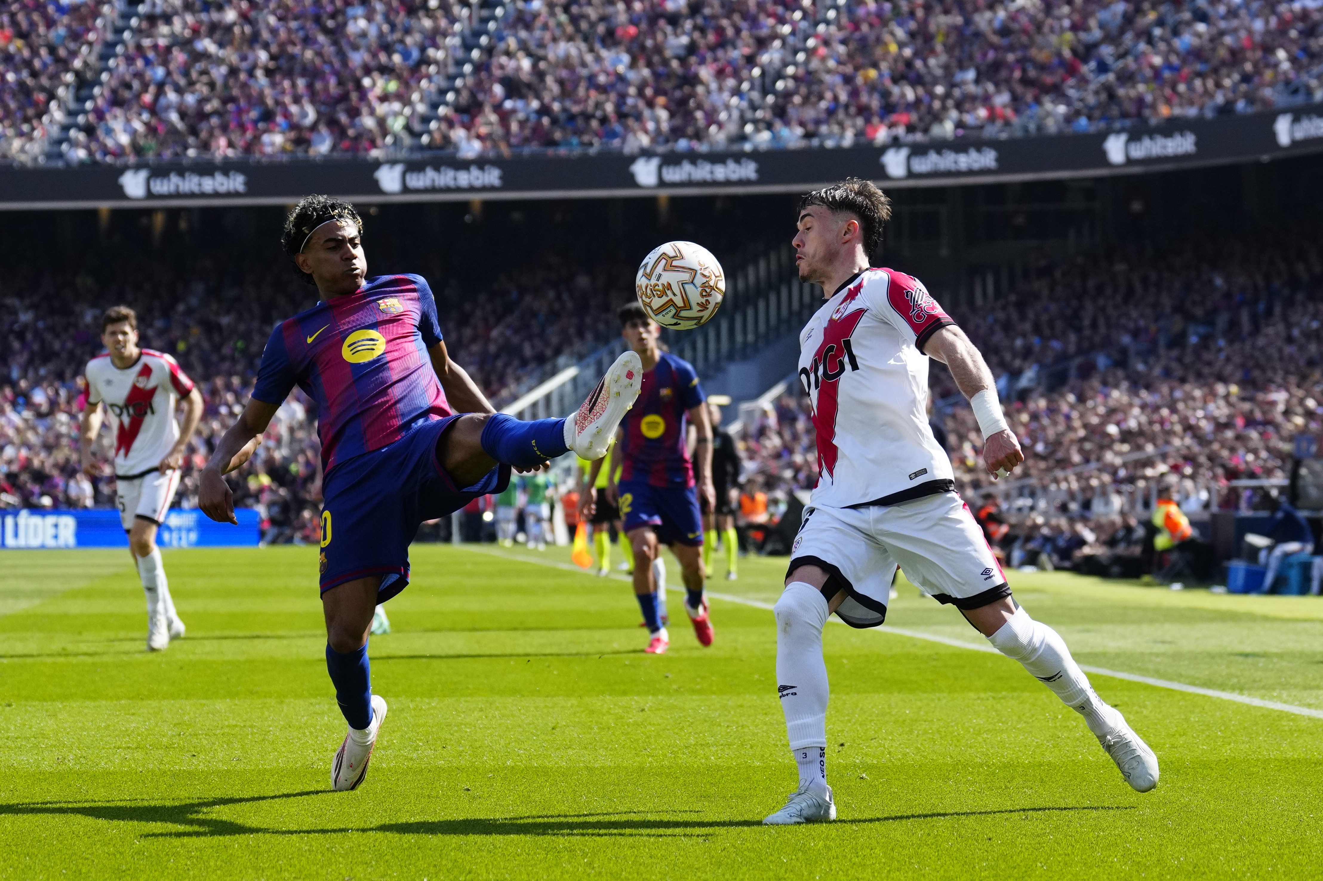 BARCELONA, 22/03/2026.- El jugador del FC Barcelona Lamine Yamal (i) lucha por el balón con Chavarría (d), del Rayo Vallecano, durante su partido de la jornada 29 de LaLiga EA Sports en el Camp Nou, este domingo. EFE/ Alejandro Garcia
