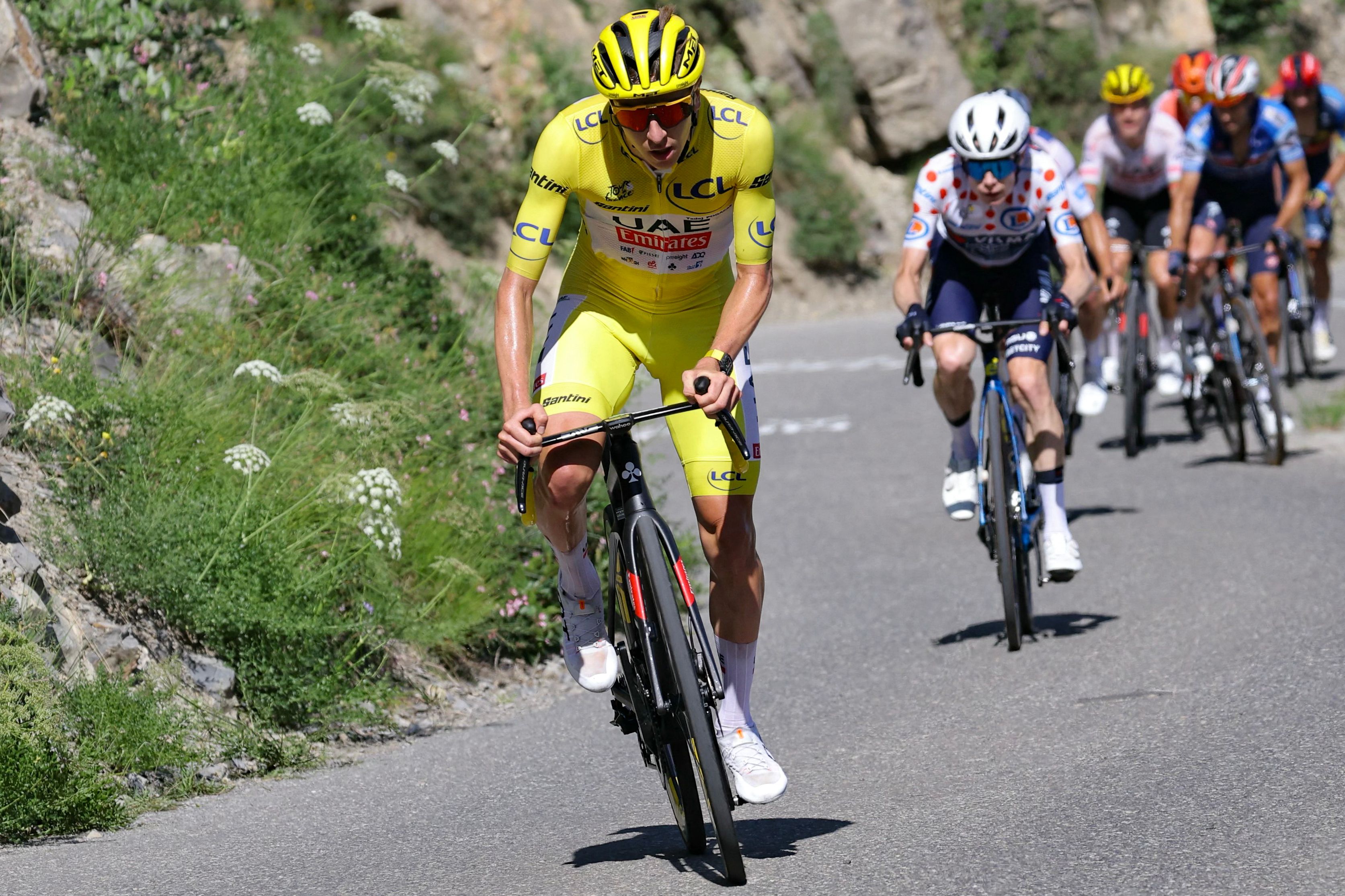 UAE Team Emirates team's Slovenian rider Tadej Pogacar wearing the overall leader's yellow jersey cycles ahead of Team Visma - Lease a Bike team's Danish rider Jonas Vingegaard in the ascent of Col du Noyer during the 17th stage of the 111th edition of the Tour de France cycling race, 177,8 km between Saint-Paul-Trois-Chateaux and Superdevoluy, in the French Alps, on July 17, 2024. (Photo by Thomas SAMSON / AFP)