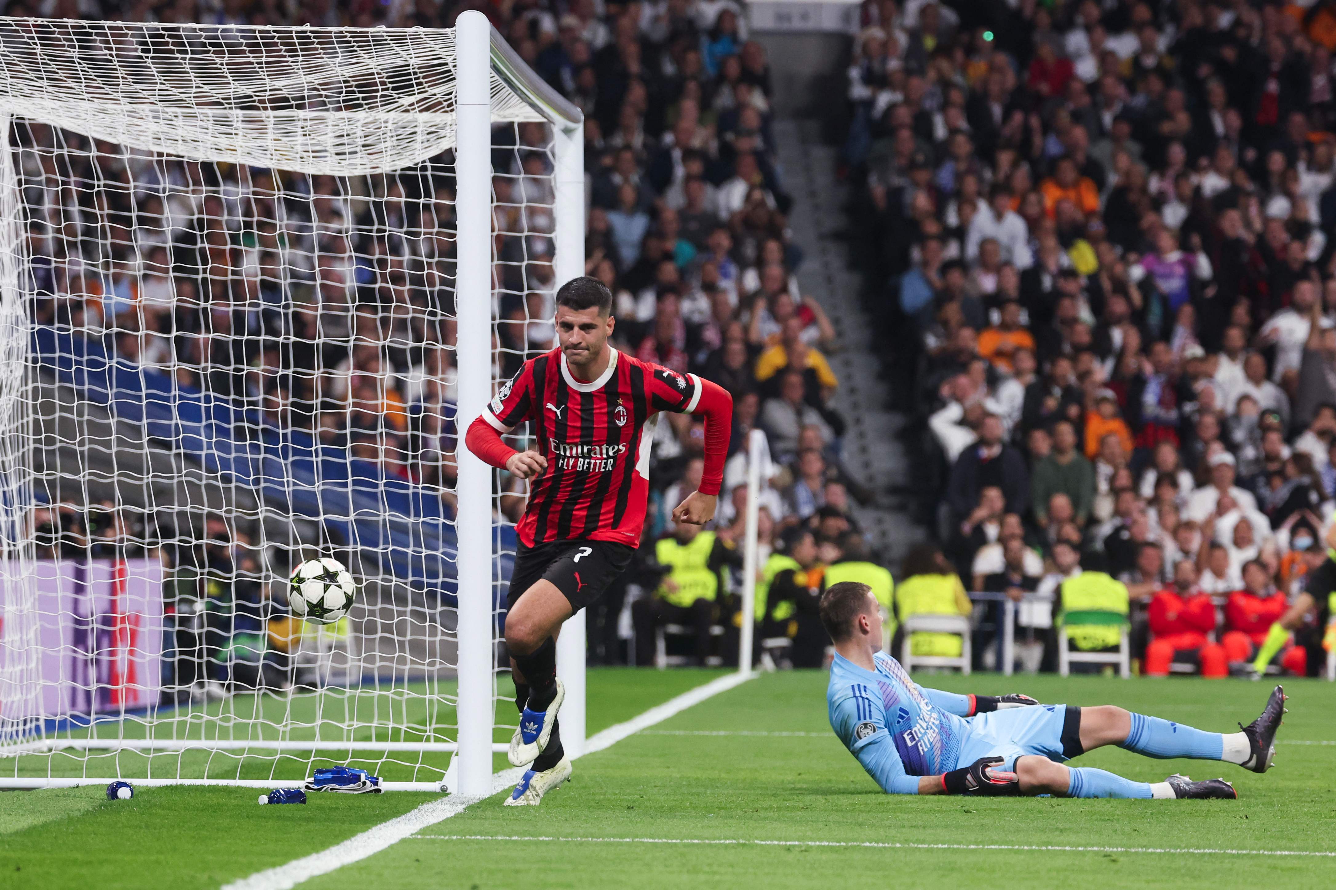 AC Milan's Spanish forward #07 Alvaro Morata (L) scores a goal past Real Madrid's Ukrainian goalkeeper #13 Andriy Lunin during the UEFA Champions League, league phase day 4 football match between Real Madrid CF and AC Milan at the Santiago Bernabeu stadium in Madrid on November 5, 2024. (Photo by Pierre-Philippe MARCOU / AFP)