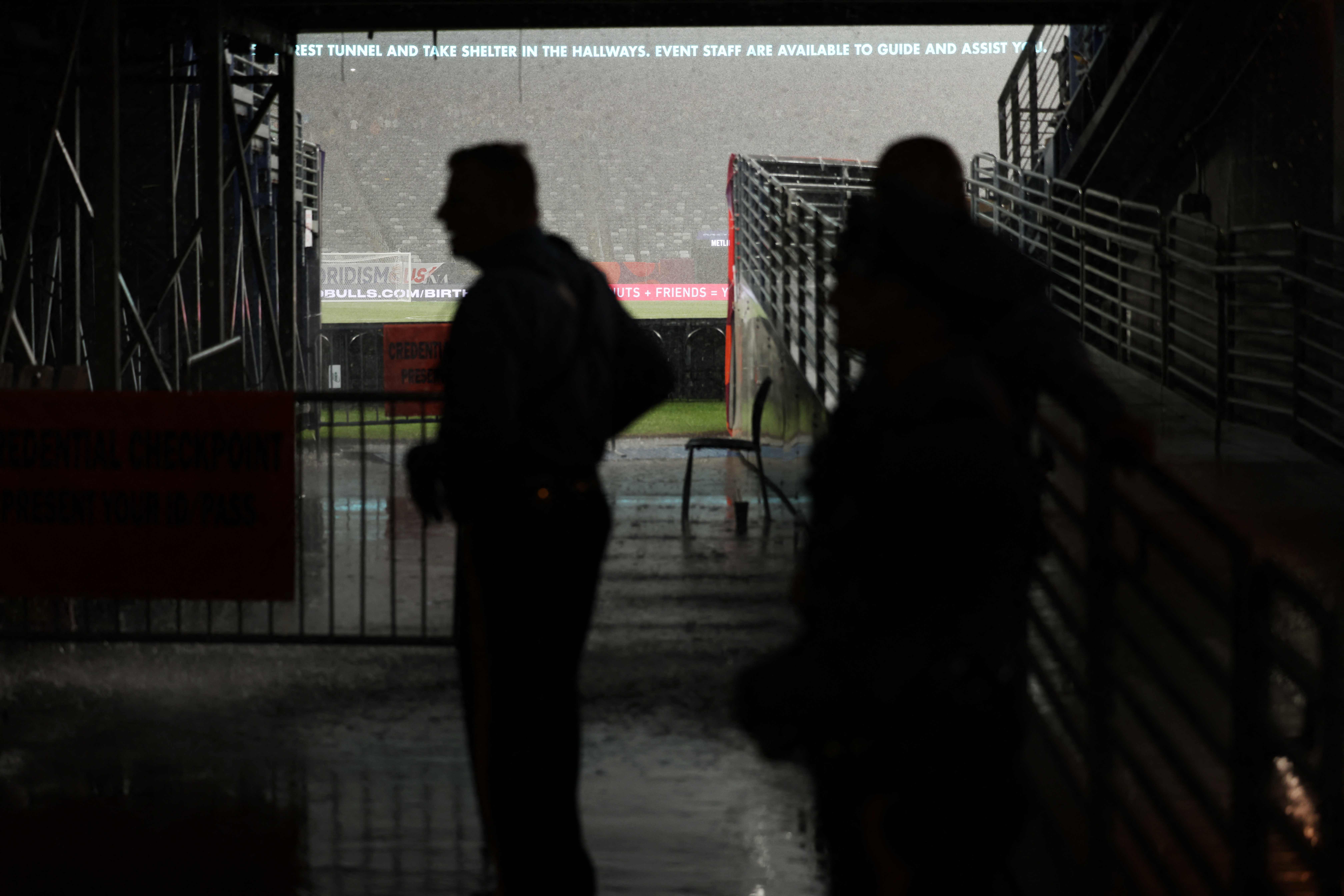 State Police officers shelter from rain as the match has been suspended during the pre-season club friendly football match between Real Madrid and FC Barcelona at MetLife Stadium, in East Rutherford, New Jersey on August 3, 2024. (Photo by Charly TRIBALLEAU / AFP)