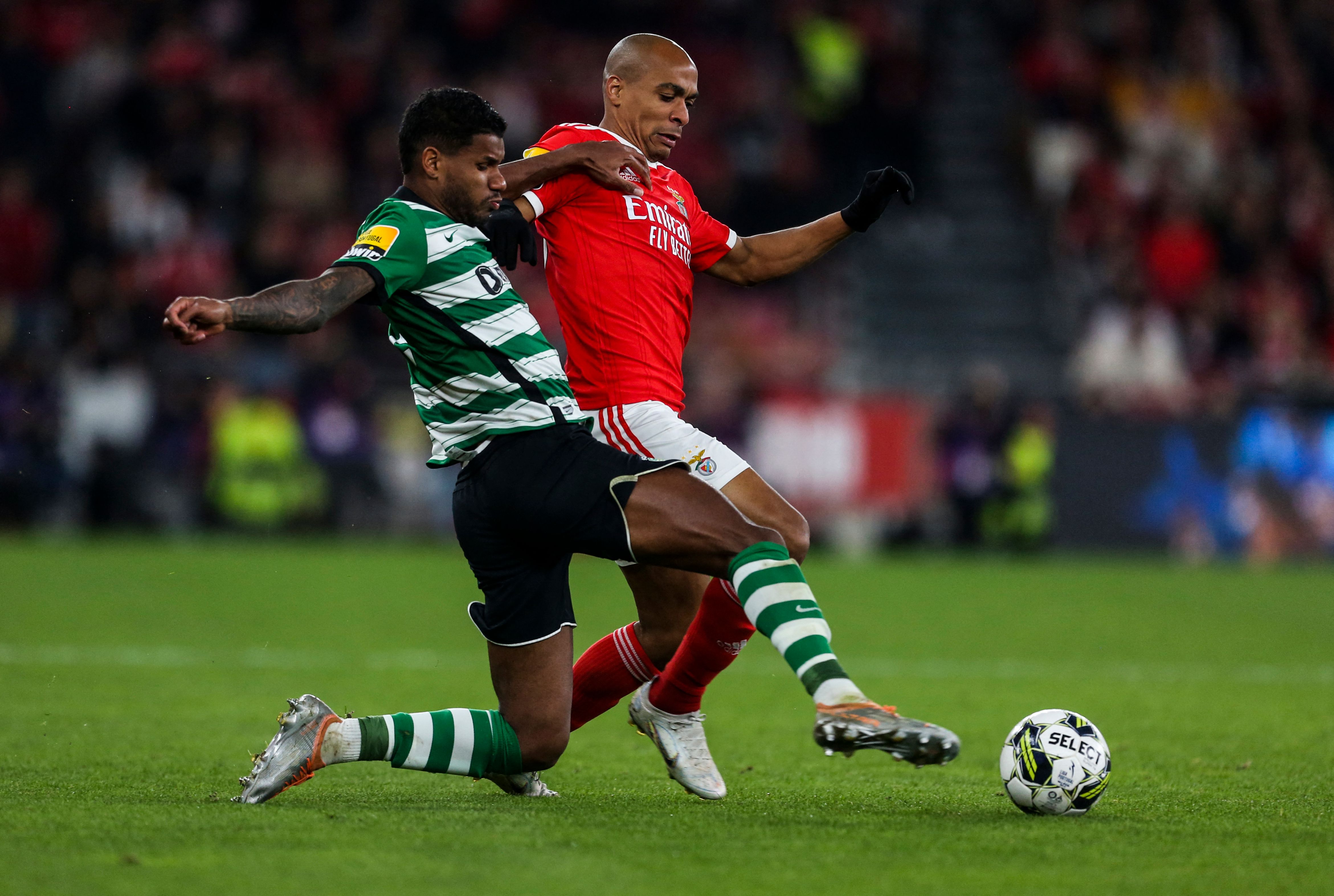 Sporting's Brazilian defender Matheus Reis (L) vies with Benfica's Portuguese midfielder Joao Mario during the Portuguese League football match between SL Benfica and Sporting CP at the Luz stadium in Lisbon on January 15, 2023. (Photo by CARLOS COSTA / AFP)