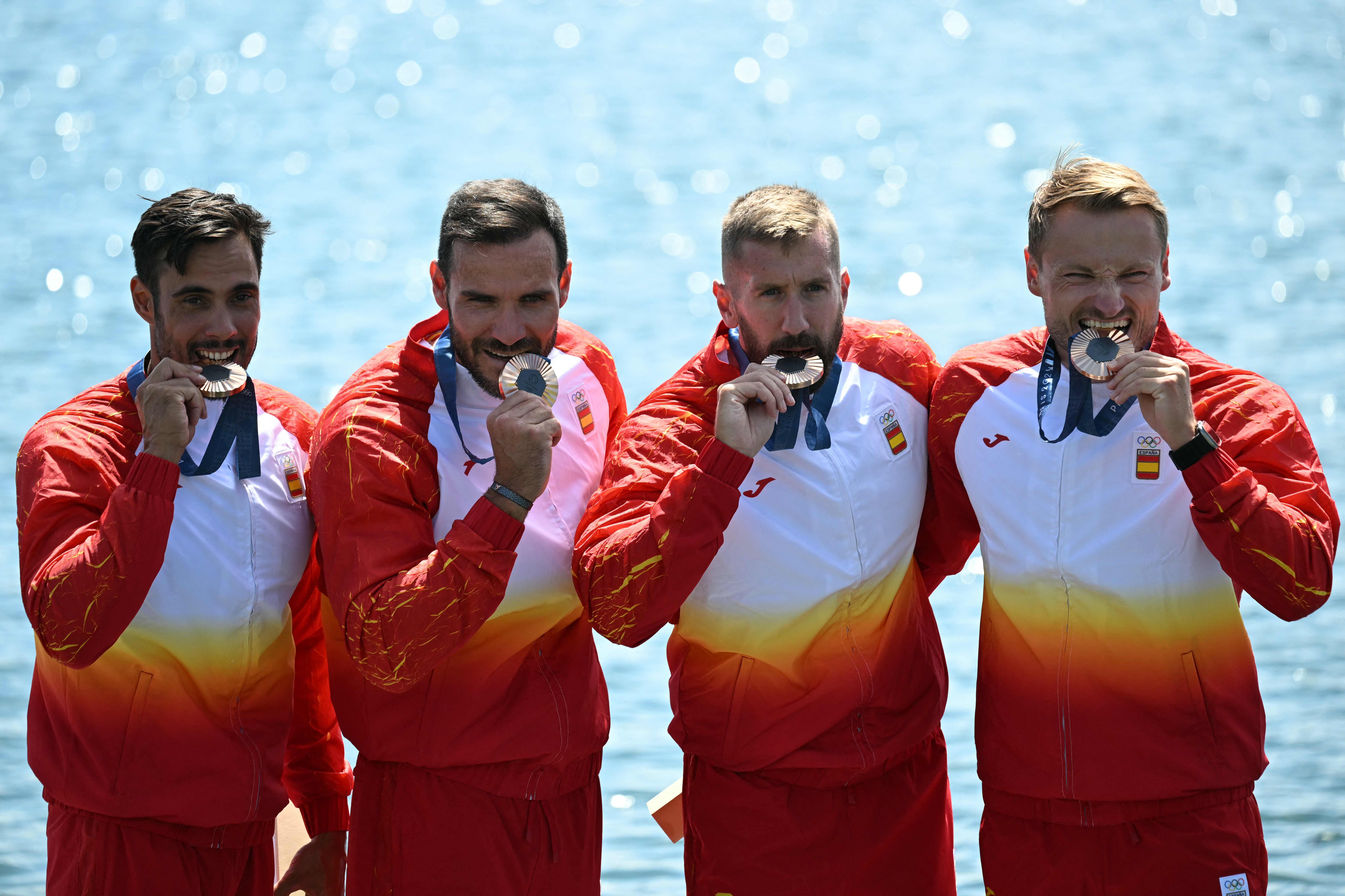 (From L) Spain's gold medallists Rodrigo Germade, Saul Craviotto, Carlos Arevalo and Marcus Cooper celebrate on the podium during the medal ceremony following the men's kayak four 500m final of the canoe sprint competition at Vaires-sur-Marne Nautical Stadium in Vaires-sur-Marne during the Paris 2024 Olympic Games on August 8, 2024. (Photo by Bertrand GUAY / AFP)