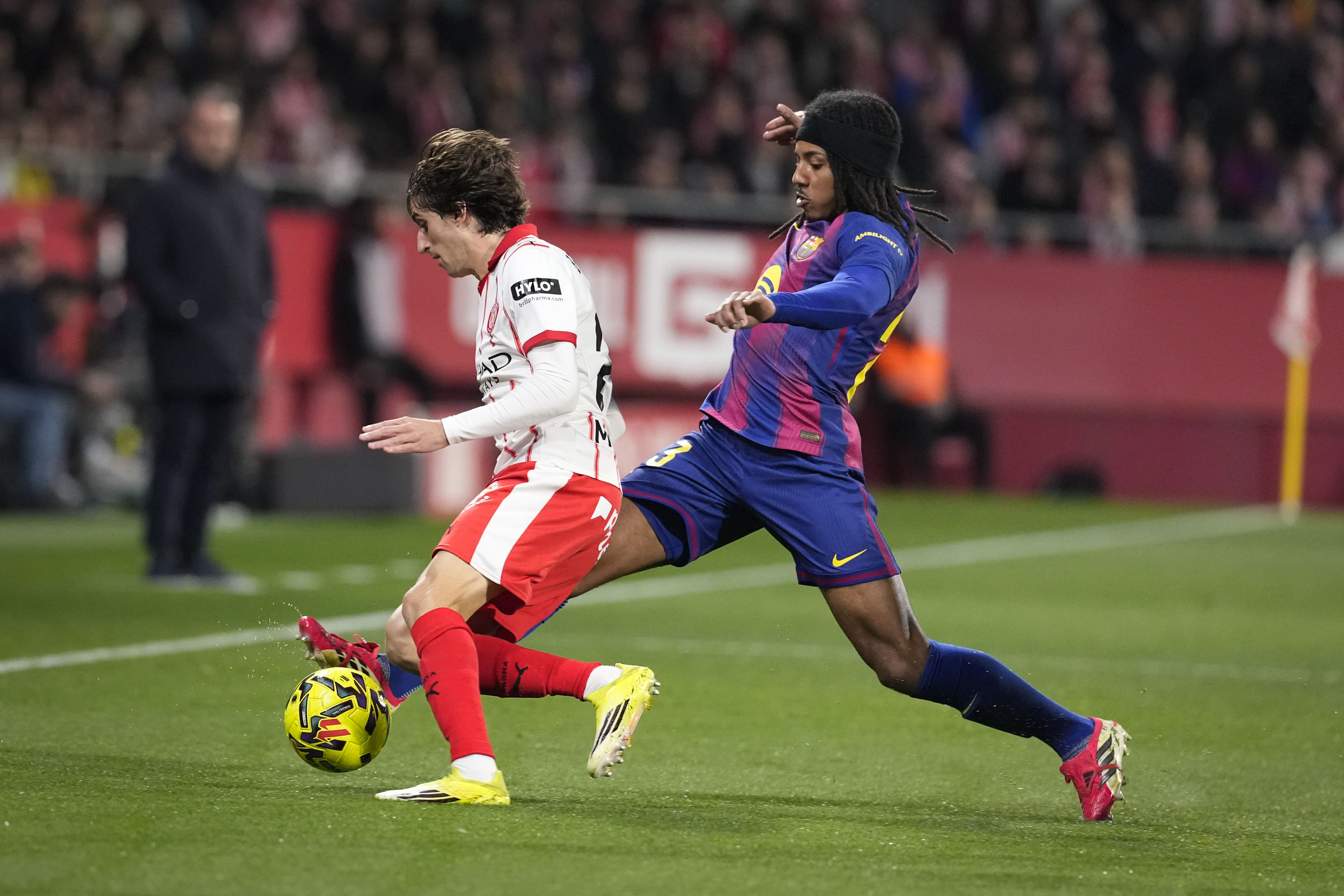 GIRONA, 16/02/2026.- El delantero del Girona Bryan Gil (i) pelea un balón con Jules Koundé, del Barcelona, durante el partido de LaLiga de fútbol que Girona FC y FC Barcelona disputan este lunes en el estadio de Moltilivi. EFE/David Borrat
