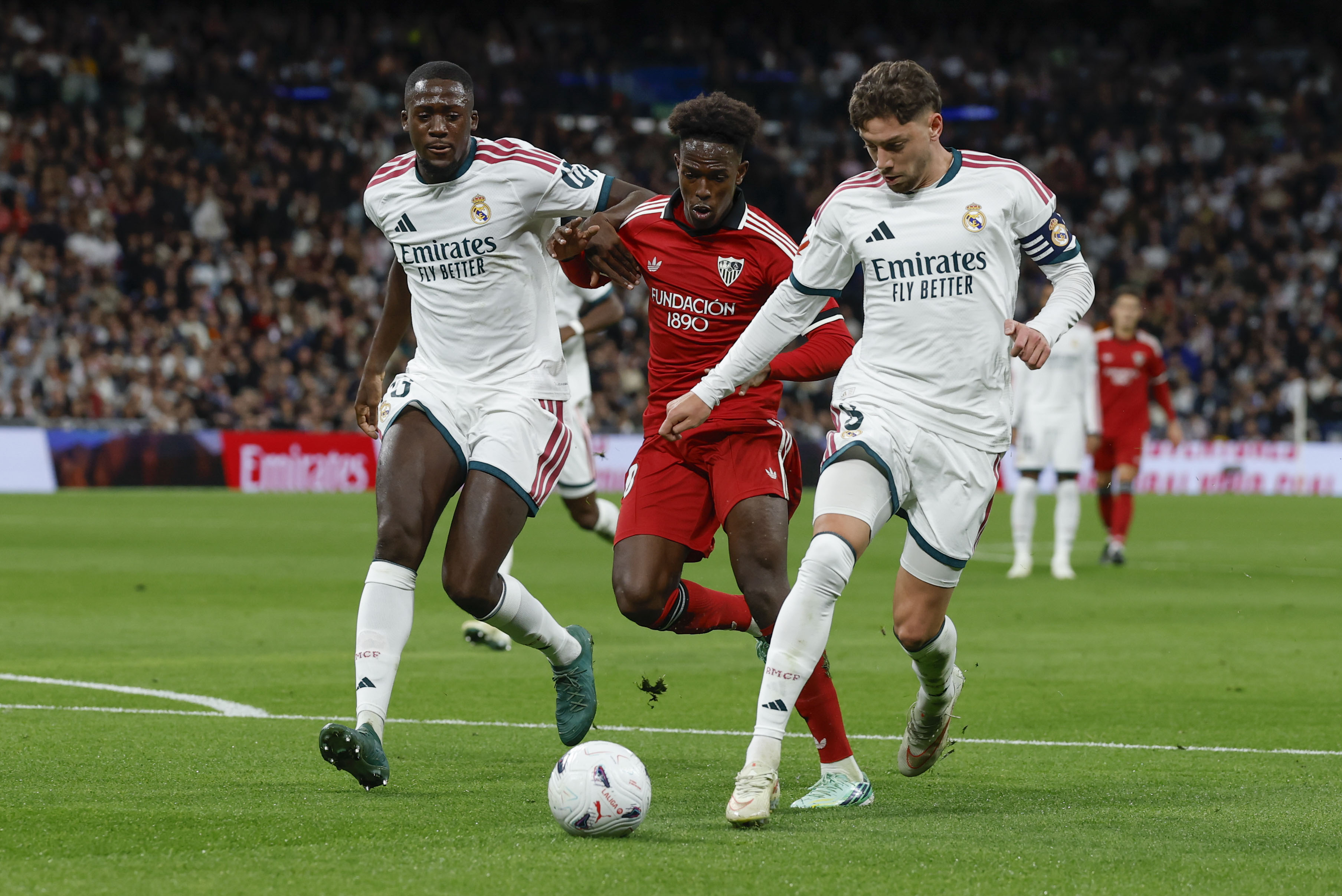 MADRID, 18/10/2026.- El centrocampista uruguayo del Real Madrid Fede Valverde (d) lucha con Félix Correia (c), del Sevilla, durante el partido de la jornada 9 de LaLiga entre el Real Madrid y el Sevilla FC, este domingo en el estadio Santiago Bernabéu. EFE/ J.J.Guillén