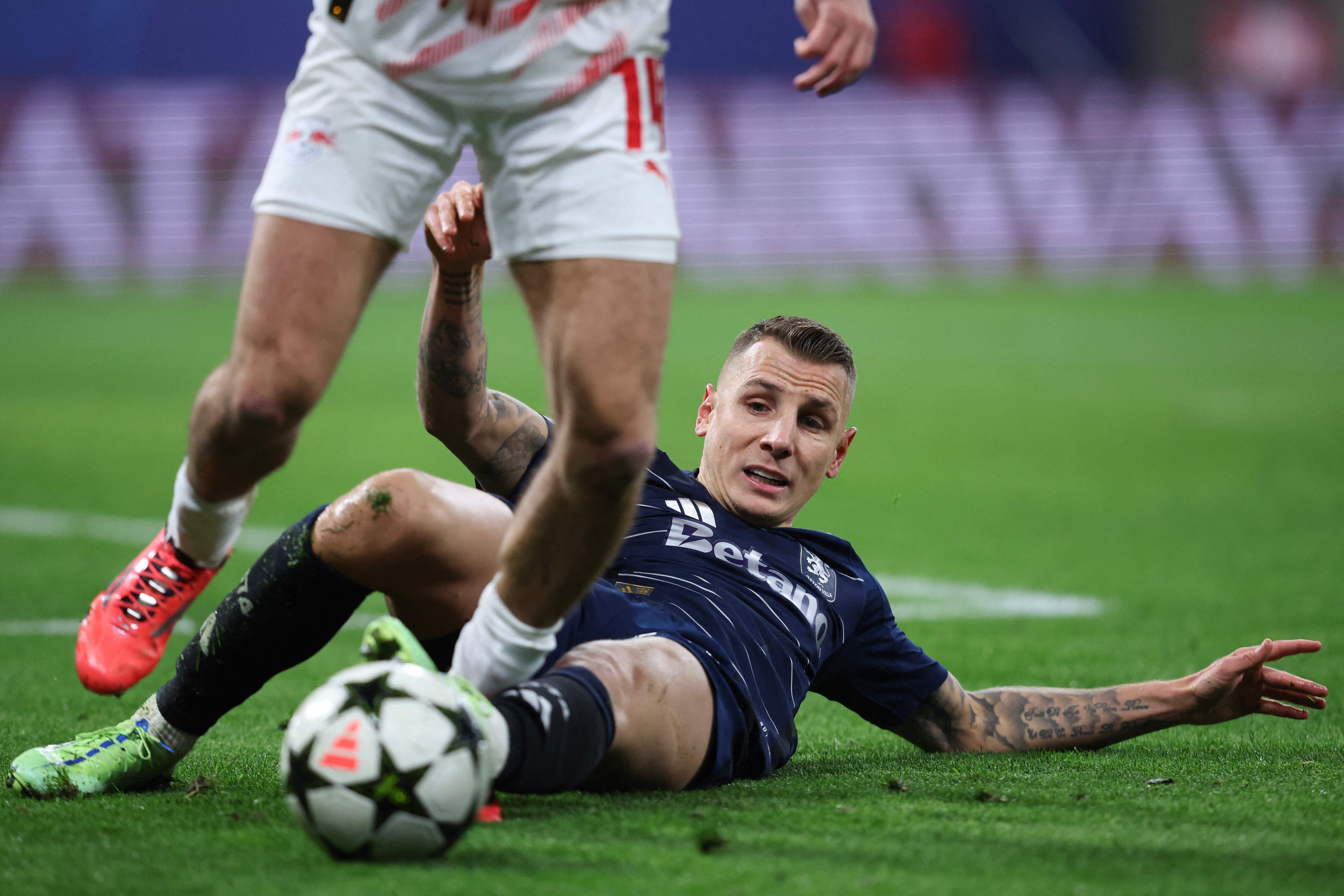 Aston Villa's French defender #12 Lucas Digne tackles the ball during the UEFA Champions League football match between RB Leipzig and Aston Villa at the RB Arena in Leipzig, eastern Germany on December 10, 2024. (Photo by Ronny HARTMANN / AFP)