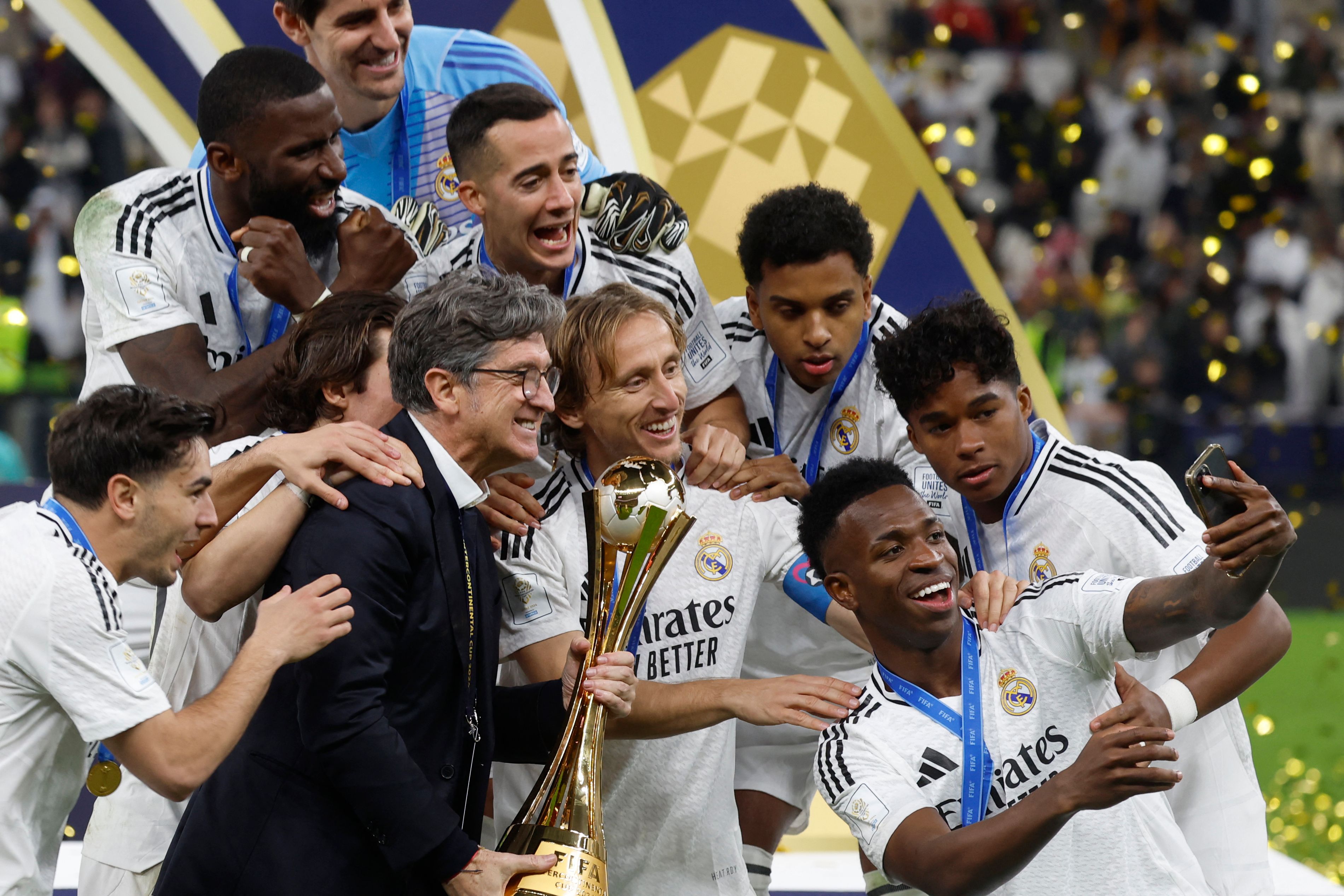 TOPSHOT - Real Madrid's Brazilian forward #7 Vinicius Junior poses for a "selfie" photo with his teammates and the tournament trophy during the podium ceremony after the 2024 FIFA Intercontinental Cup final football match between Spain's Real Madrid and Mexico's Pachuca at the Lusail Stadium in Doha on December 18, 2024. (Photo by KARIM JAAFAR / AFP)