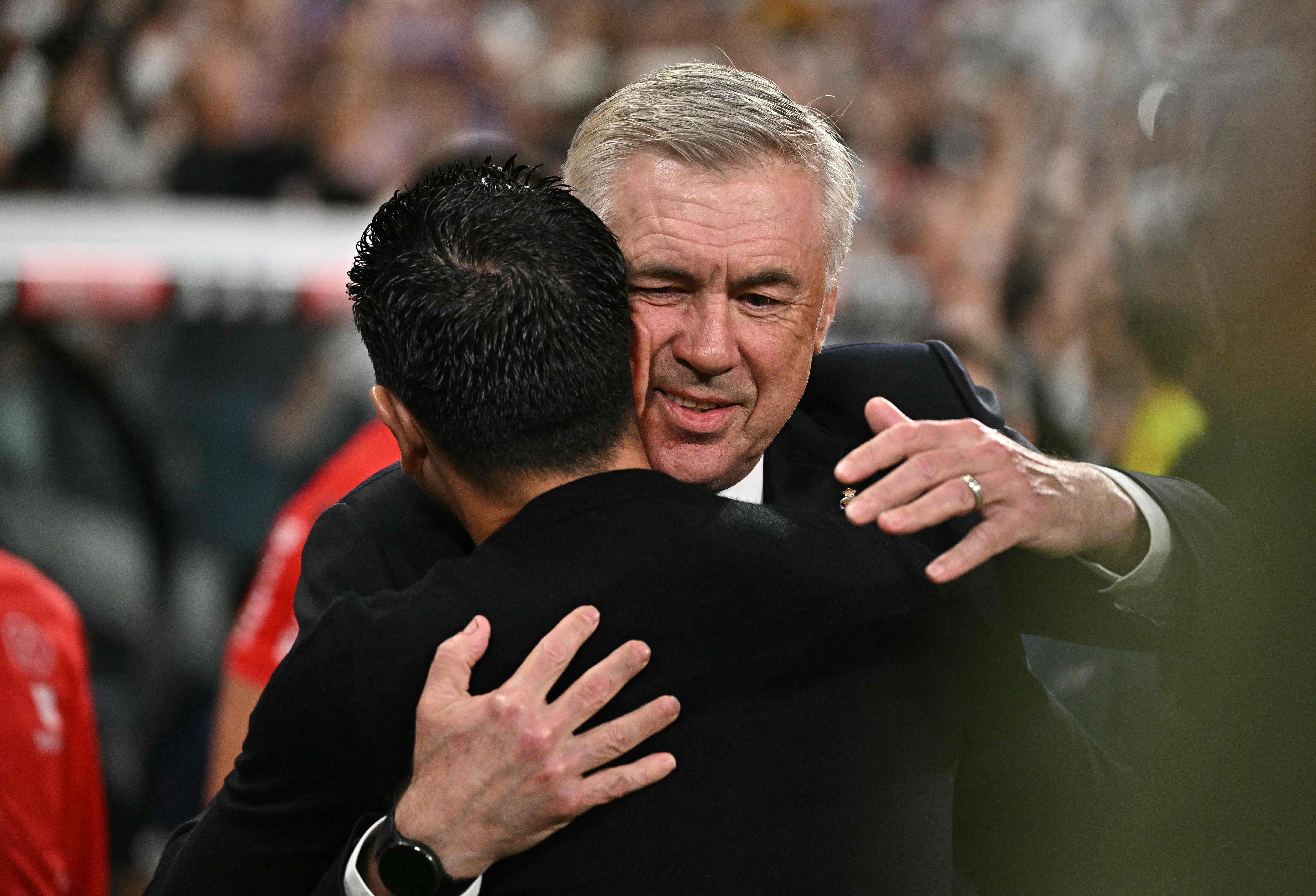 Real Madrid's Italian coach Carlo Ancelotti hugs Barcelona's Spanish coach Xavi prior the Spanish league football match between Real Madrid CF and FC Barcelona at the Santiago Bernabeu stadium in Madrid on April 21, 2024. (Photo by JAVIER SORIANO / AFP)