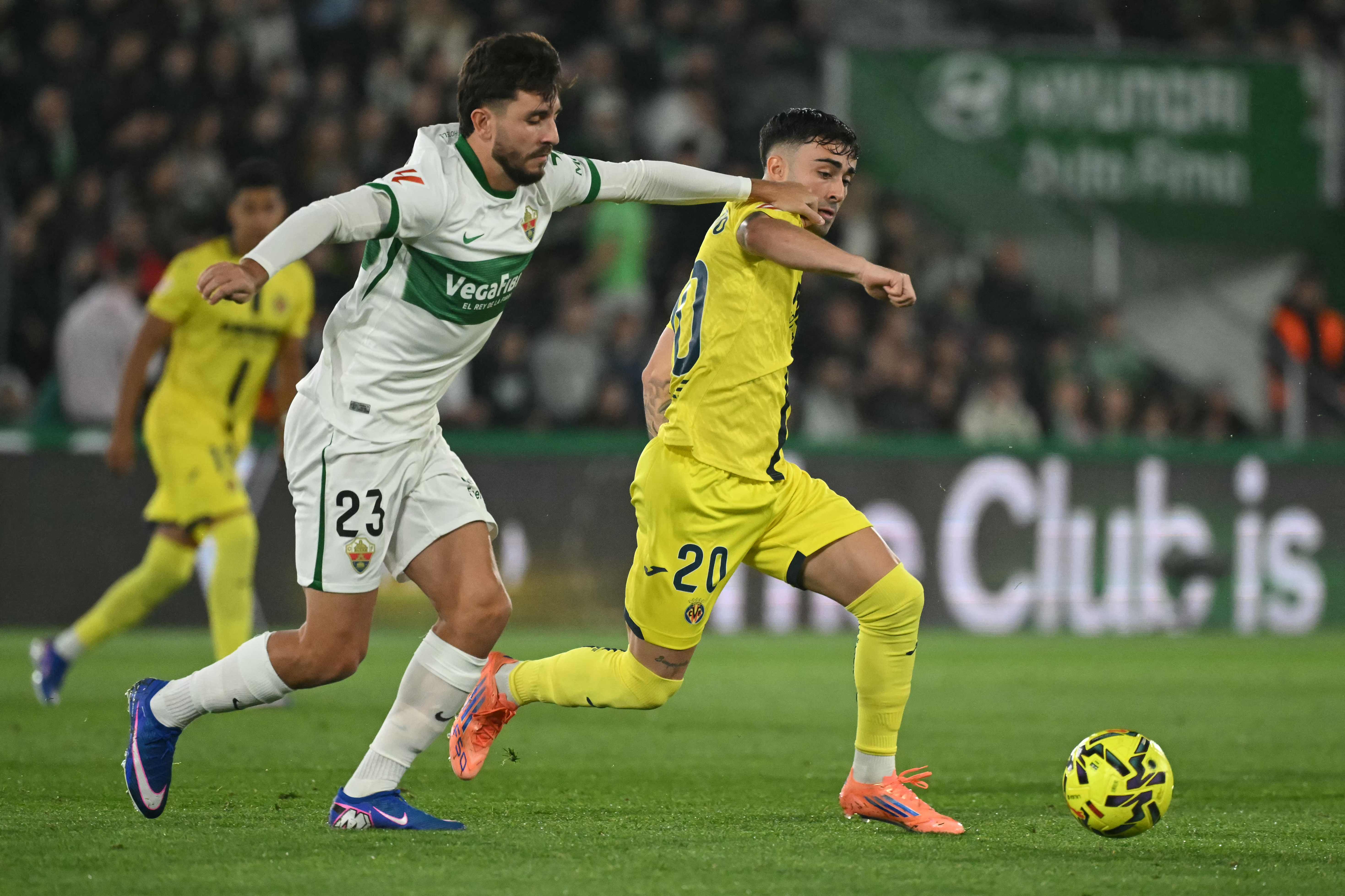 Elche's Spanish defender #23 Victor Chust and Villarreal's Spanish forward #20 Alberto Moleiro fight for the ball during the Spanish League football match between Elche CF and Villarreal CF at Martinez Valero Stadium in Elche on January 3, 2026. (Photo by JOSE JORDAN / AFP)