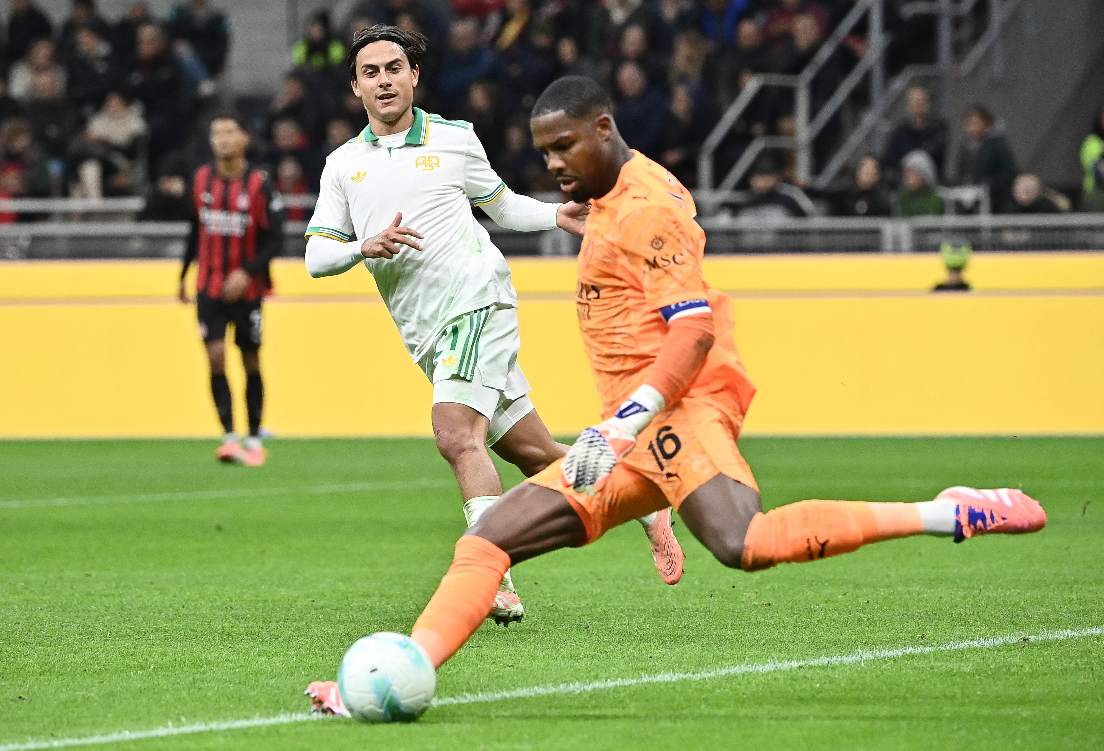 Roma's Argentinian forward #21 Paulo Dybala (L) watches as AC Milan's French goalkeeper #16 Mike Maignan kicks the ball during the Italian Serie A football match between AC Milan and AS Roma at San Siro stadium in Milan, on November 2, 2025. (Photo by Isabella BONOTTO / AFP)