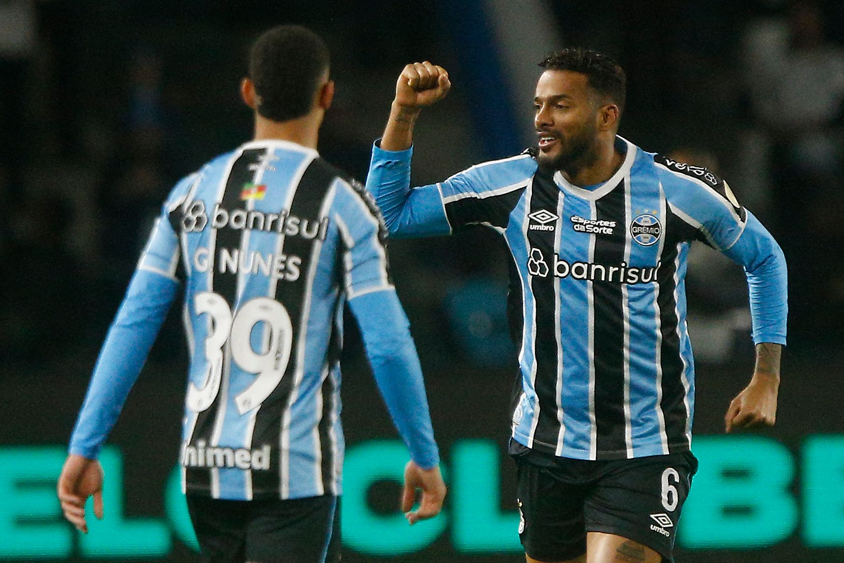 Gremio's defender Reinaldo (R) celebrates with Gremio's midfielder Gustavo Nunes after scoring his second goal during the Copa Libertadores round of 16 first leg all-Brazilian football match between Gremio and Fluminense, at the Arena do Gremio stadium, in Porto Alegre, Brazil, on August 13, 2024. (Photo by Albari Rosa / AFP)